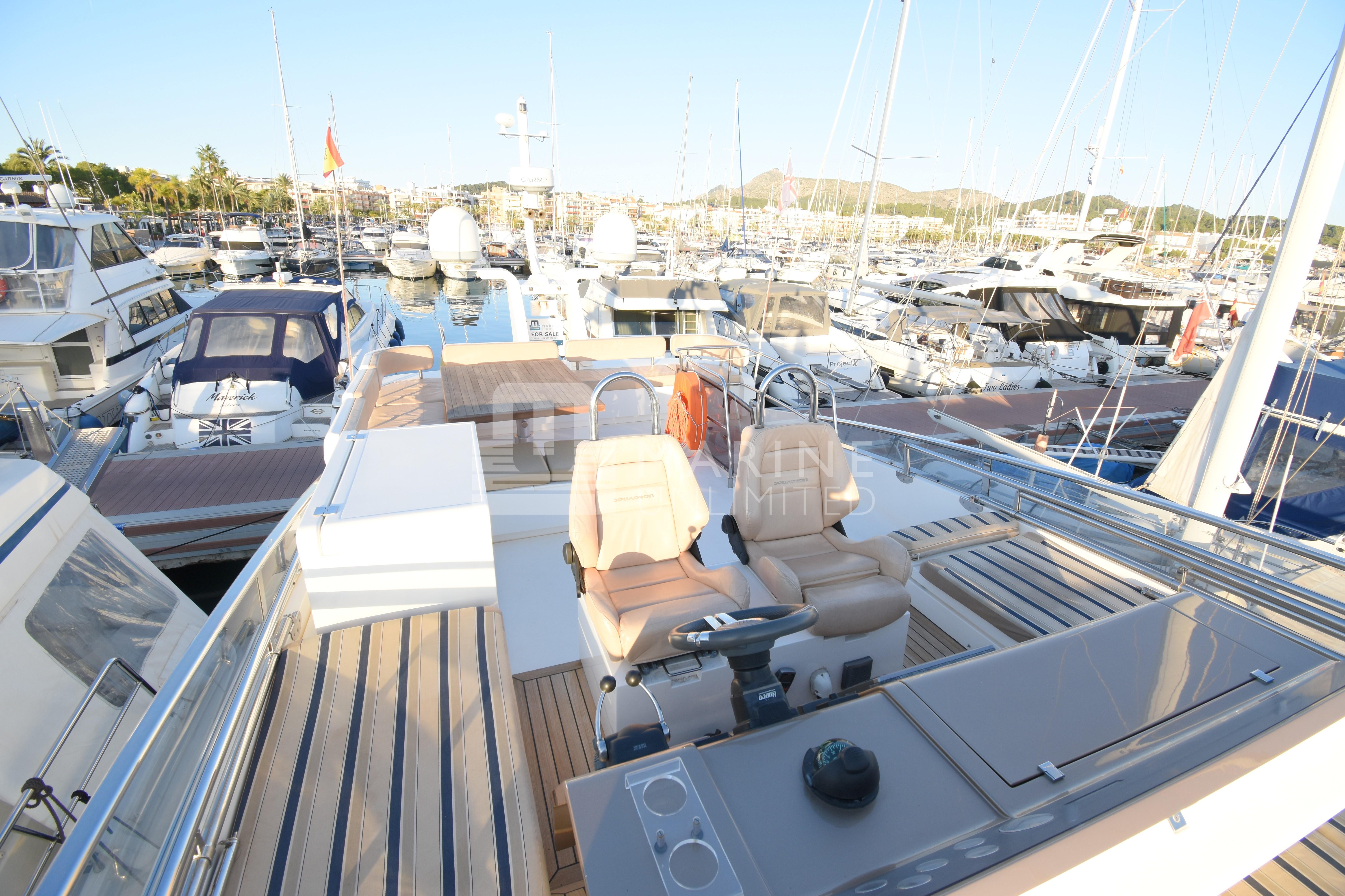 2010 Fairline Squadron 55 yacht in a marina, featuring spacious deck and seating area.