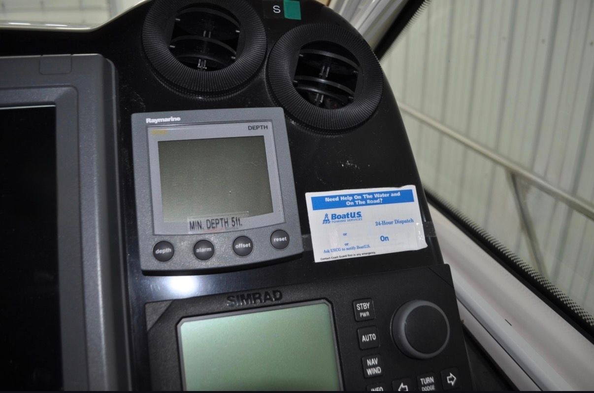 Close-up of a boat dashboard with Raymarine and Simrad equipment.