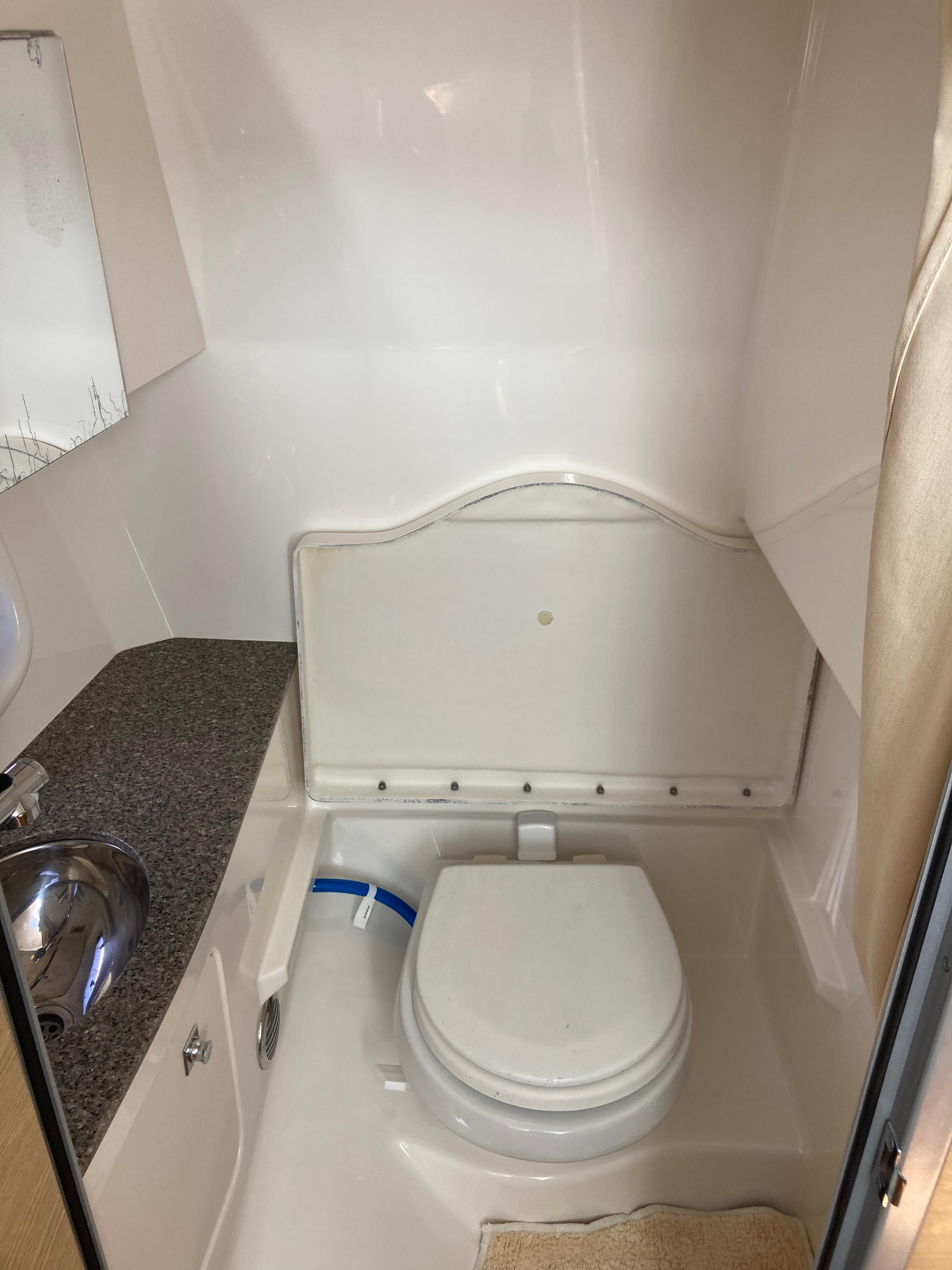 2015 Chaparral 327 SSX boat bathroom with toilet and sink.
