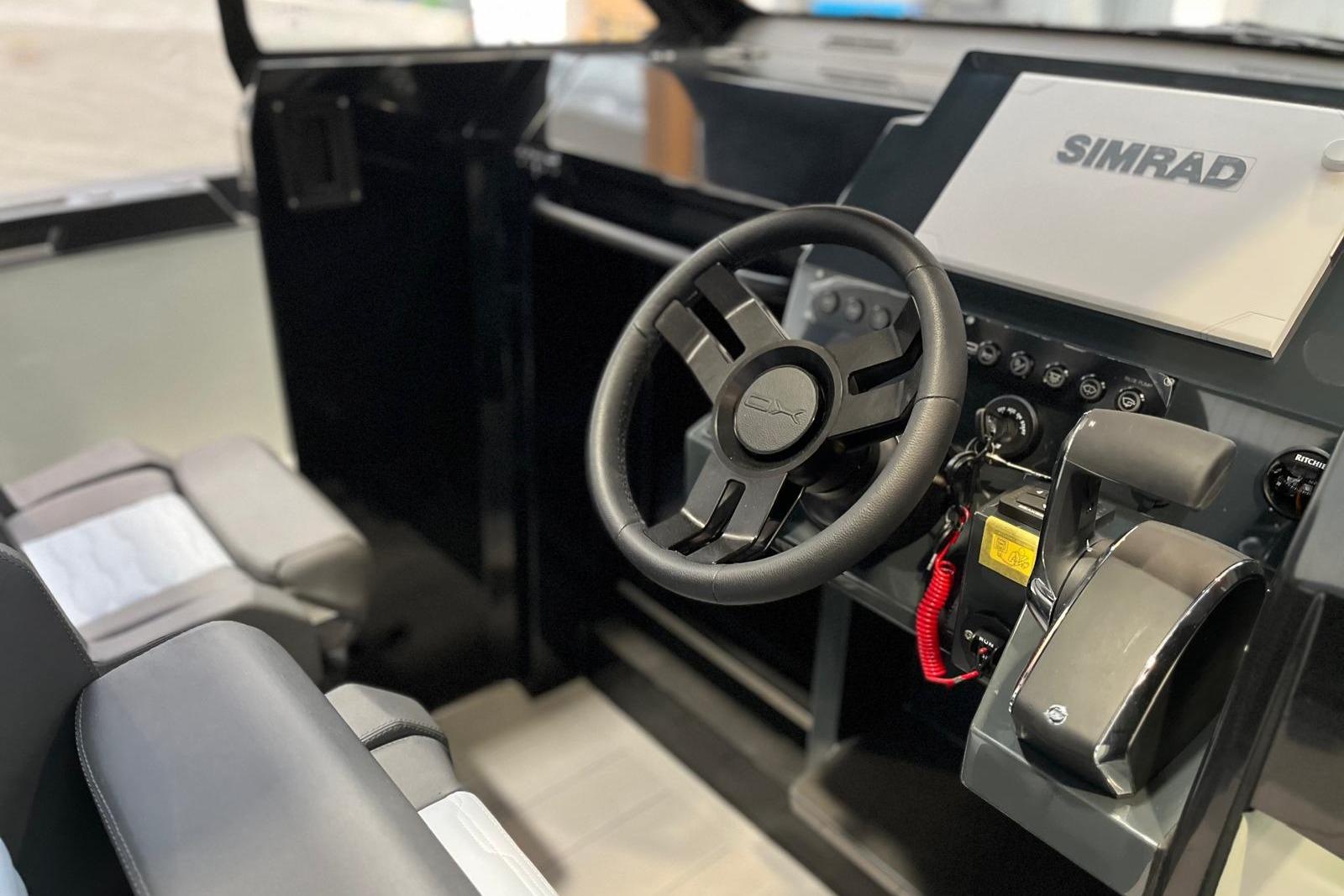 Interior cockpit of 2026 XO DFNDR A8 boat with steering wheel and Simrad display.