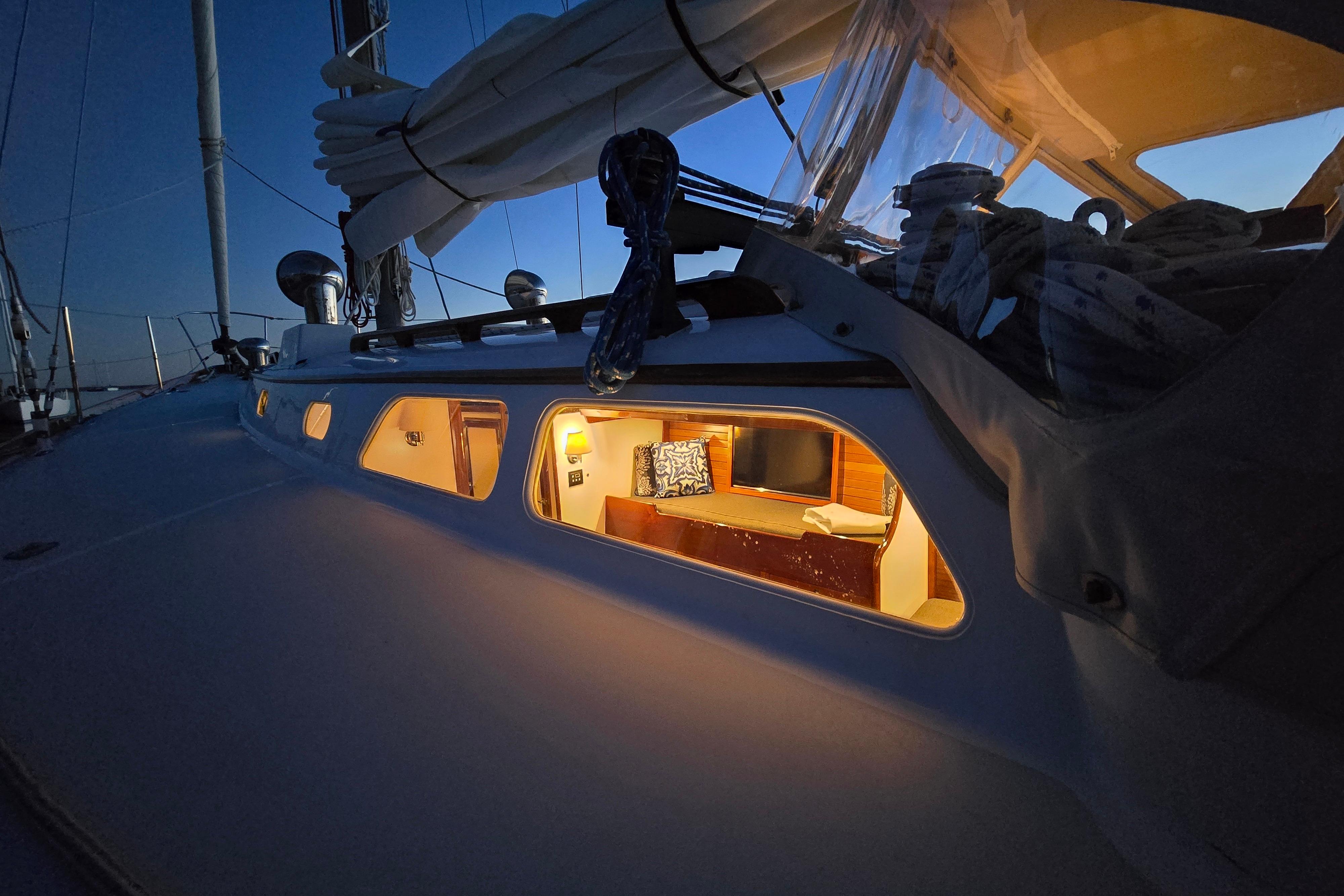 1970 Hinckley Bermuda 40 sailboat cabin illuminated at dusk, showcasing cozy interior.