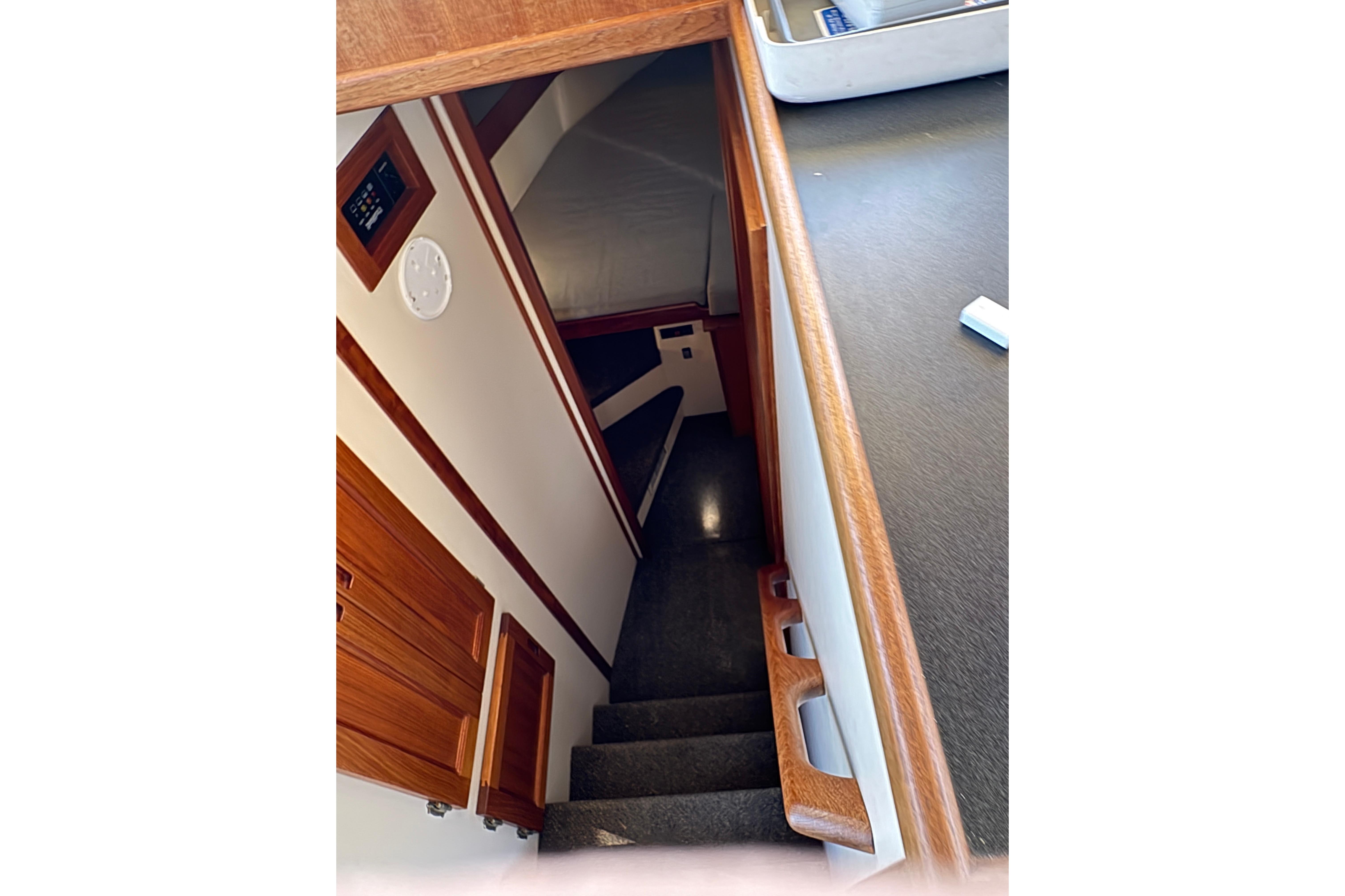 Interior view of 2004 Nordic Tug 32, featuring wooden stairs and cozy cabin space.