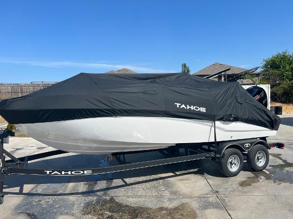 2024 Tahoe T21 boat with cover on trailer in driveway.