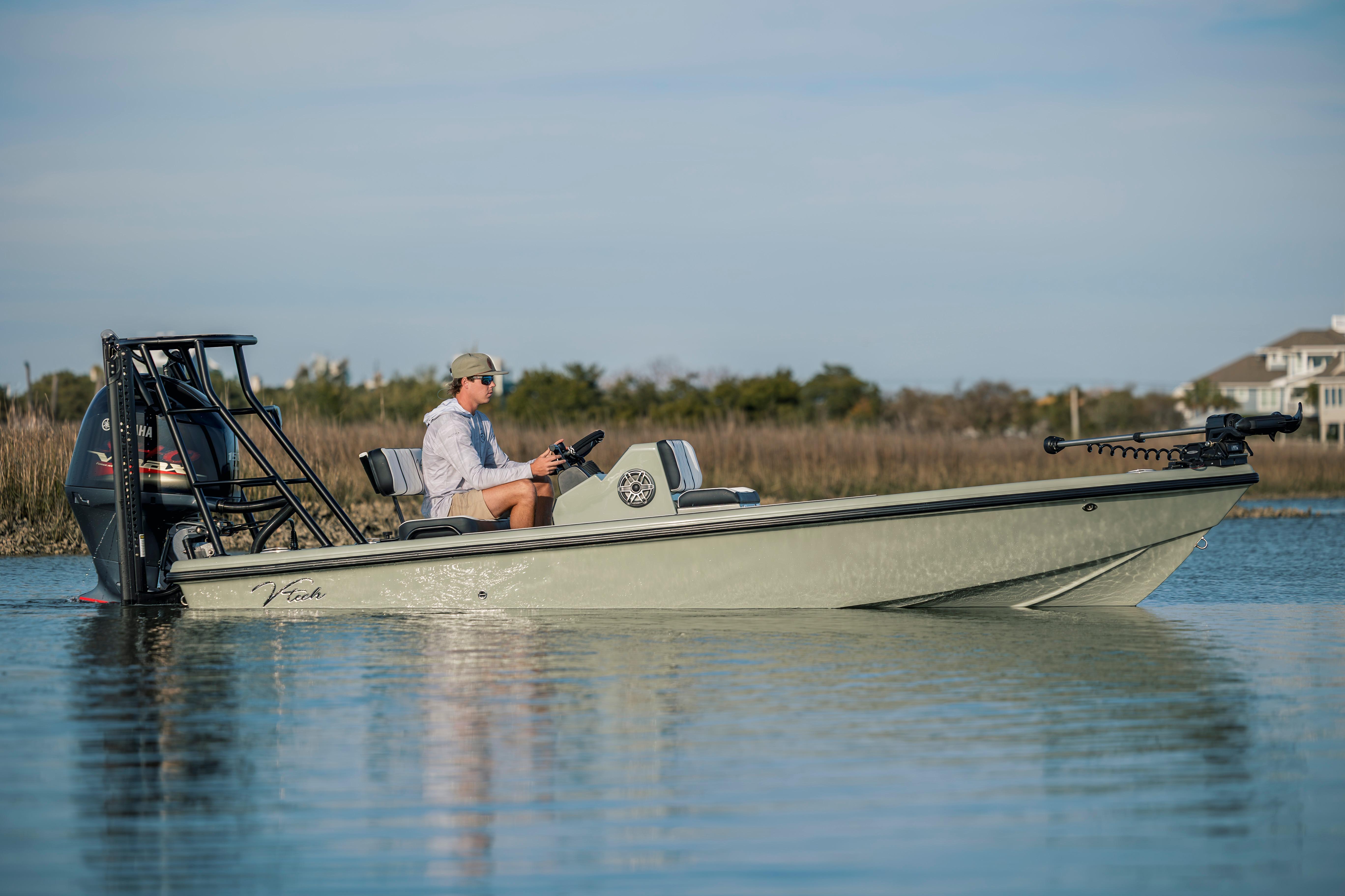 2025 Vtech 18 boat on calm water, person steering, scenic background.