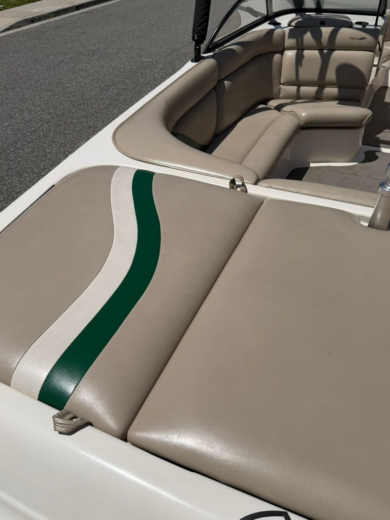 Interior of a Tigé 21V boat with beige seats and a green stripe.
