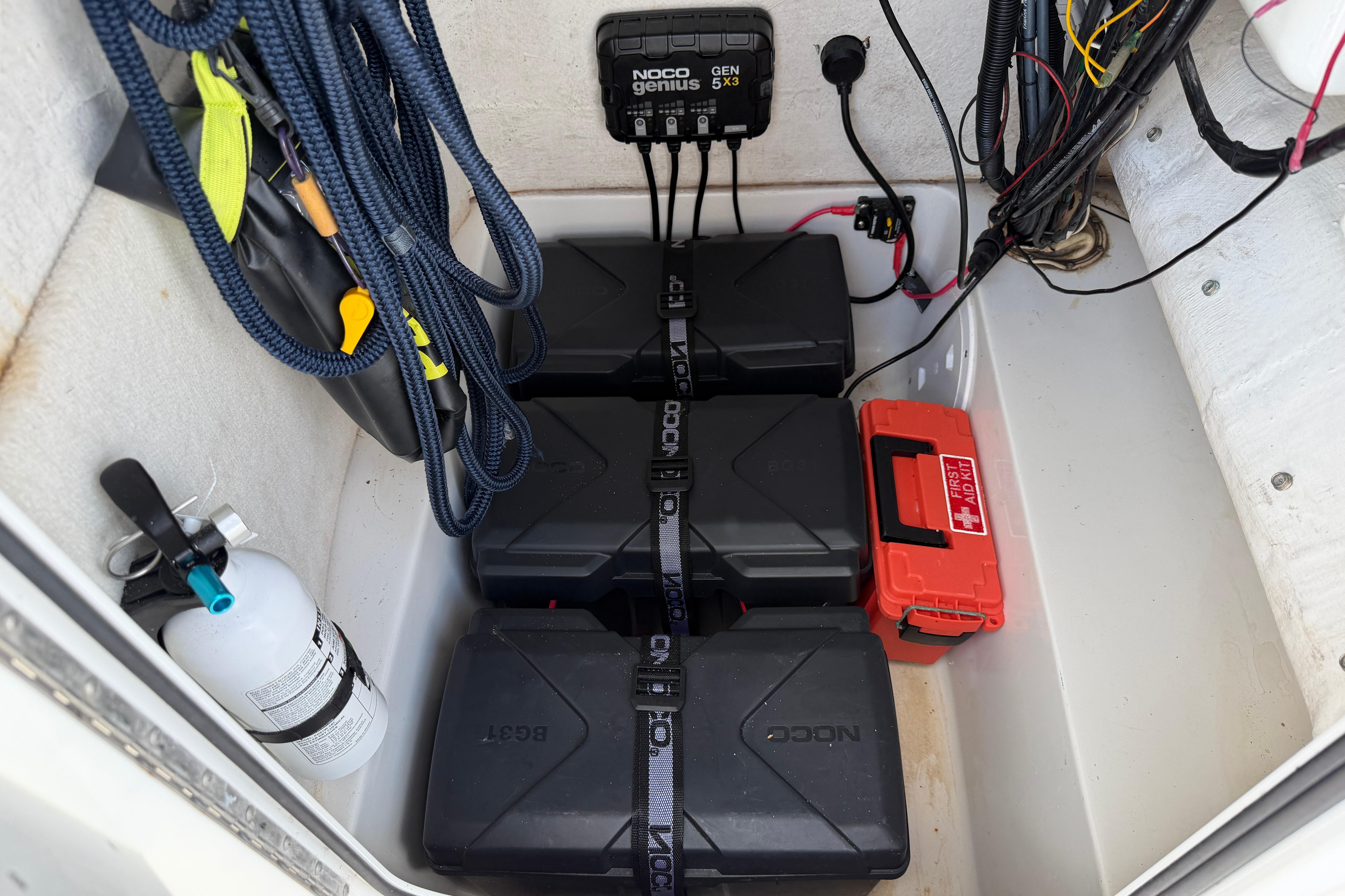2015 Sea Hunt Triton 225 boat storage with batteries, charger, fire extinguisher, and first aid kit.
