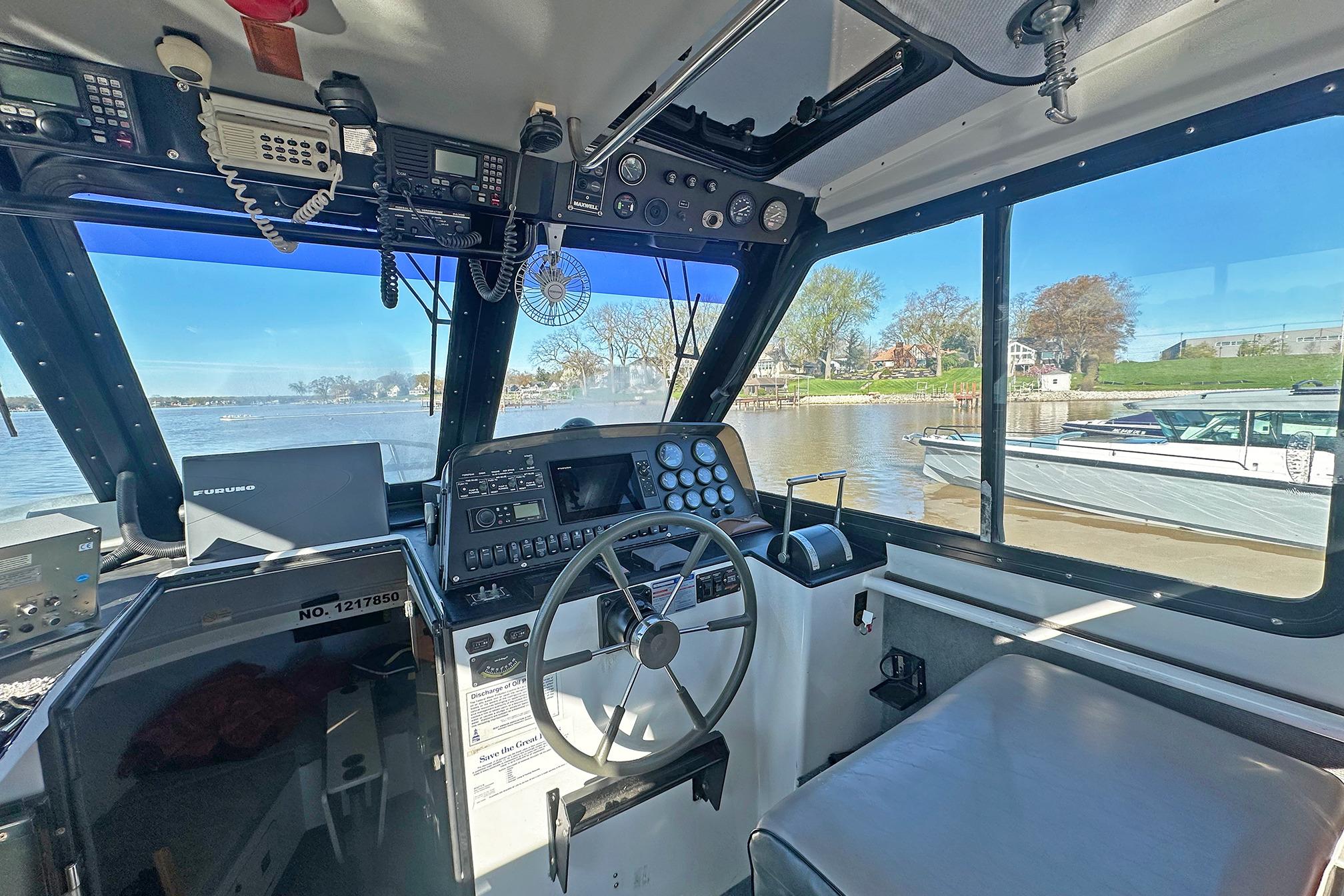 Interior view of a 1990 Boston Whaler 36 Defiance boat cockpit with navigation equipment.