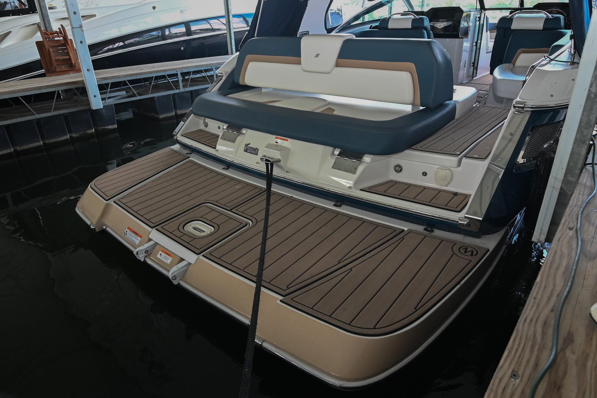 2014 Four Winns H290 boat with spacious deck and seating in a marina.