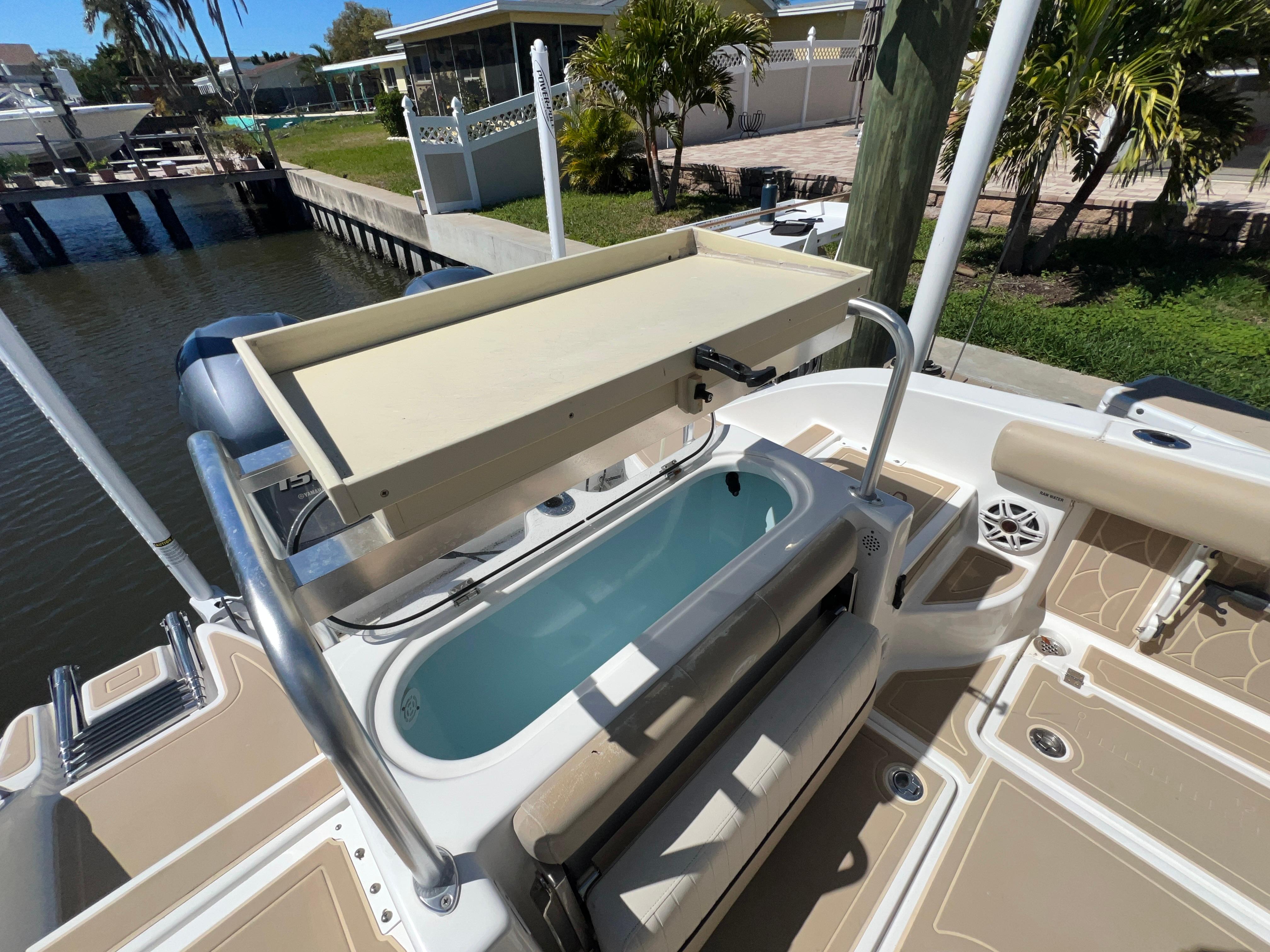 2016 Sea Fox 266 Commander boat with fishing station and livewell, docked by a canal.