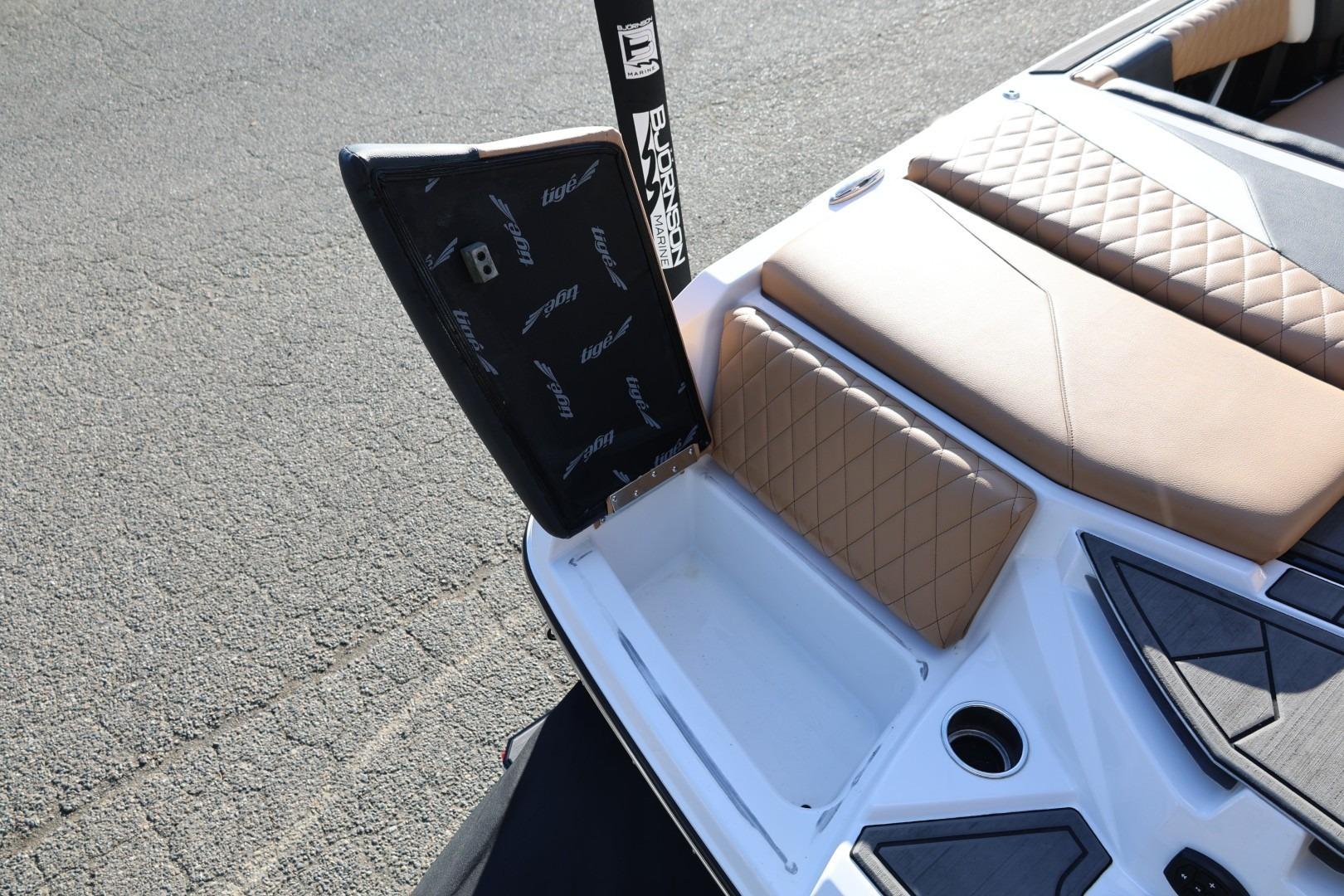 2023 Tigé Z3 boat with open storage compartment and tan quilted seating.