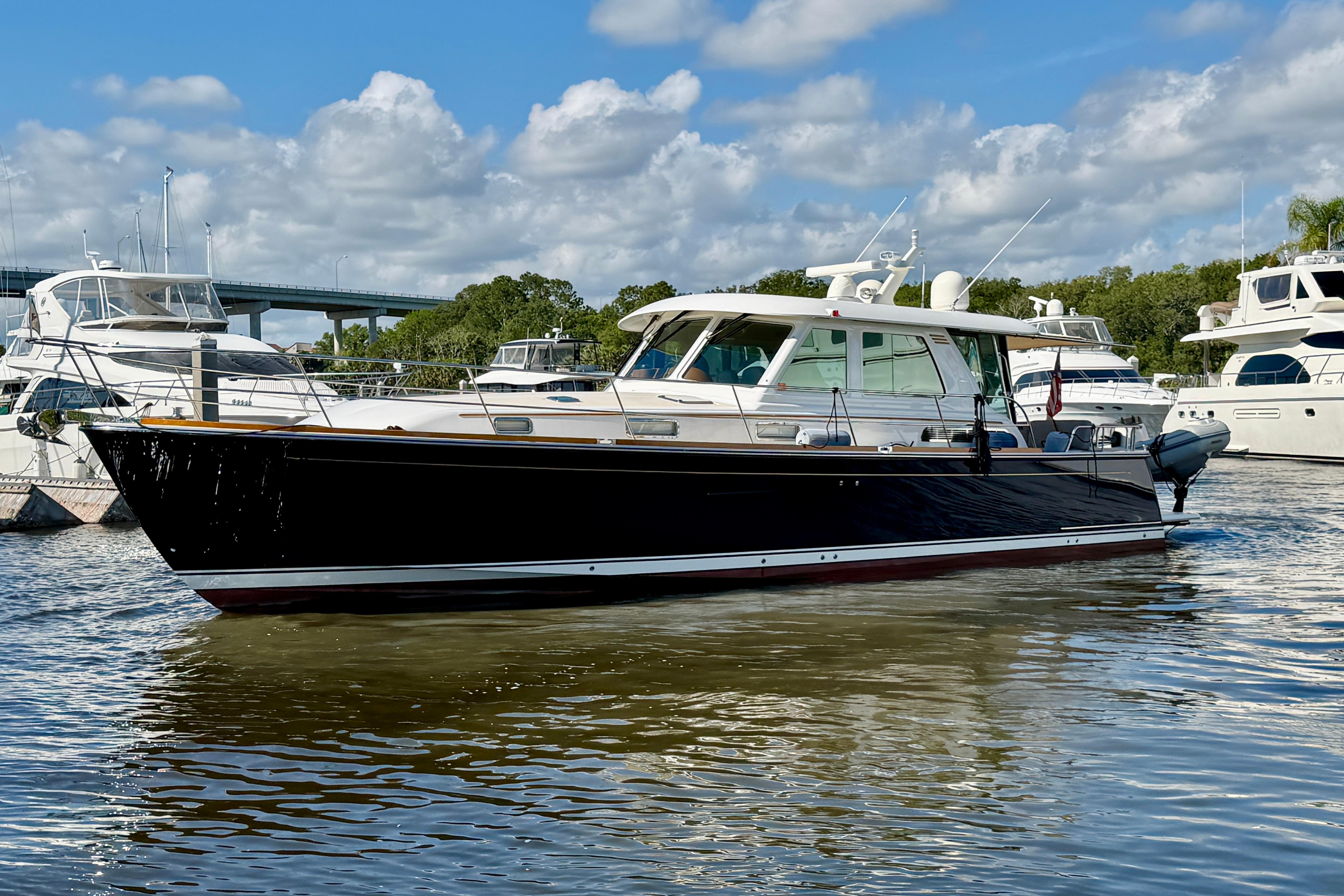 2016 Sabre 48 Salon Express yacht docked in a marina under a blue sky.