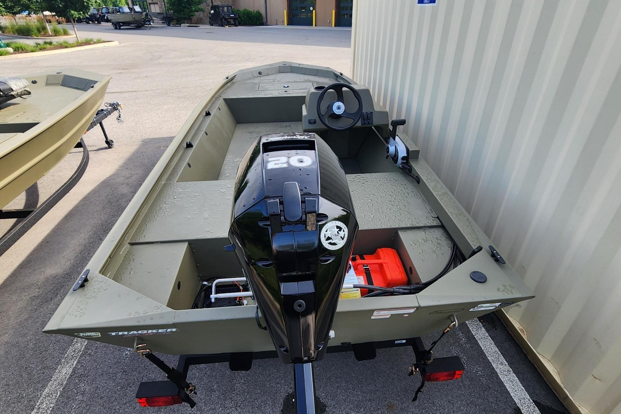 2026 Tracker Grizzly 1648 SC boat with 20 HP motor, parked outdoors.