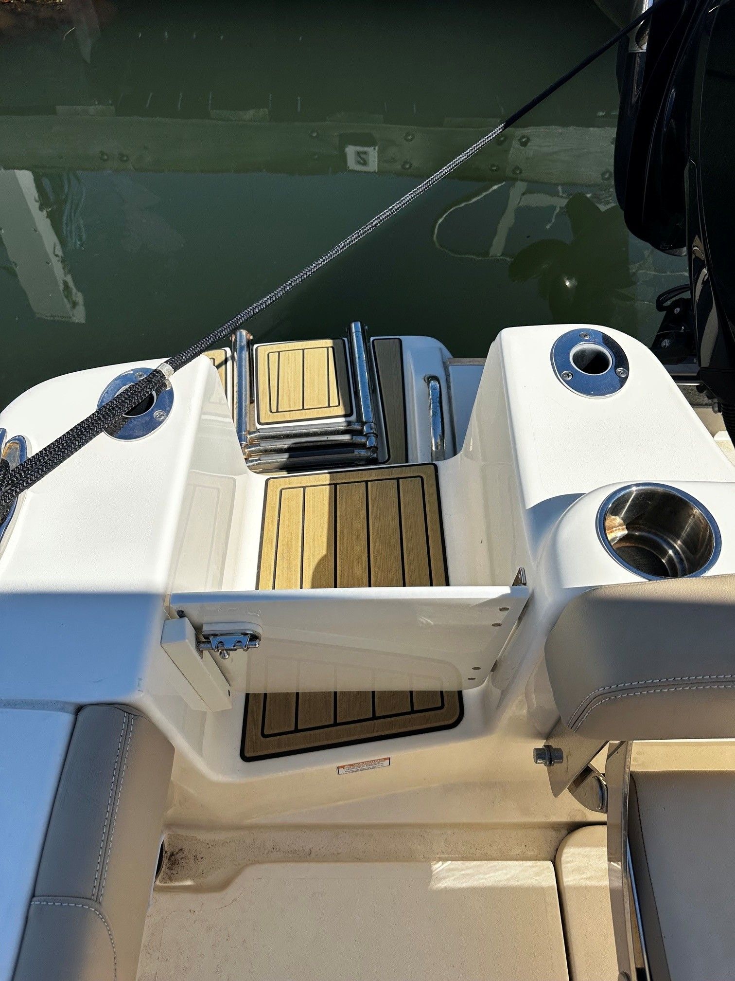 2022 Scout 210XSF boat with teak details by the water.