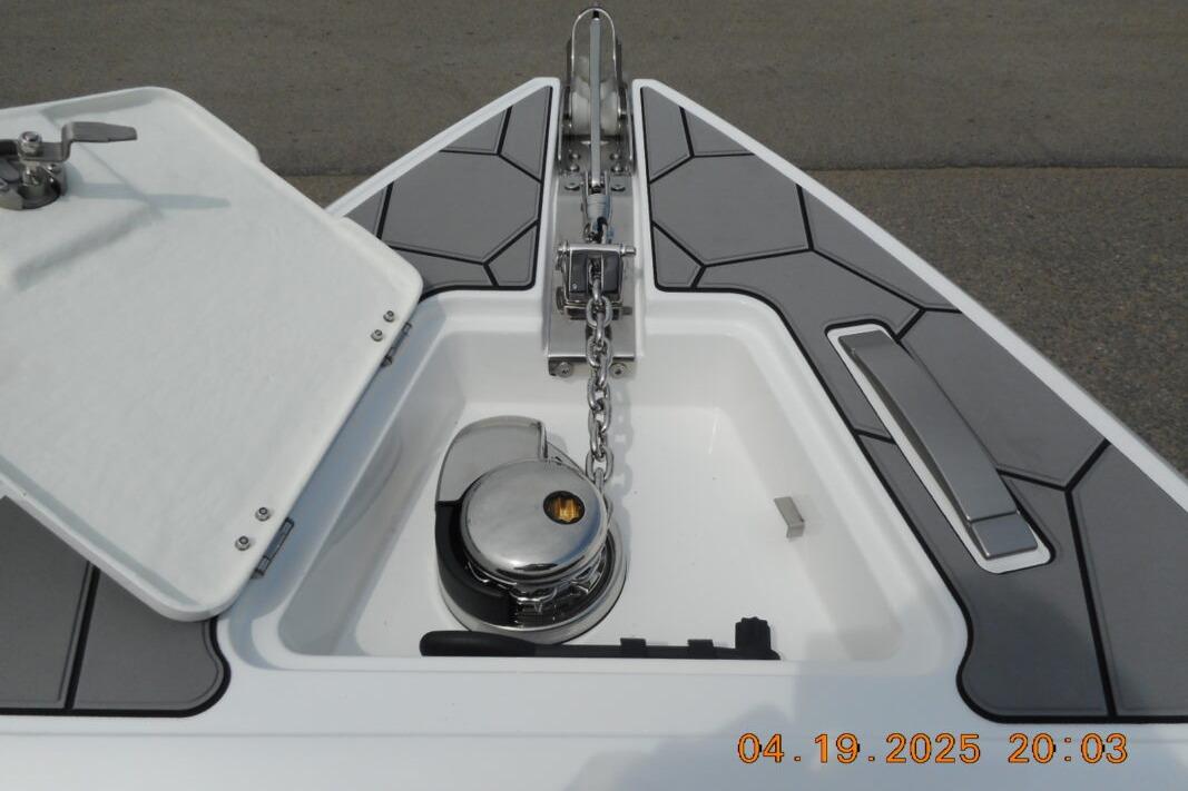 Bow anchor compartment of 2025 Highfield Sport 760 boat with chain and winch.