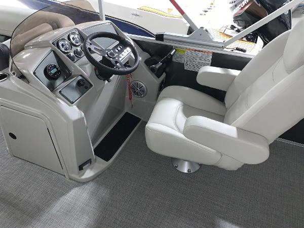 2024 Starcraft EX22 FD boat cockpit with steering wheel and captain's chair.