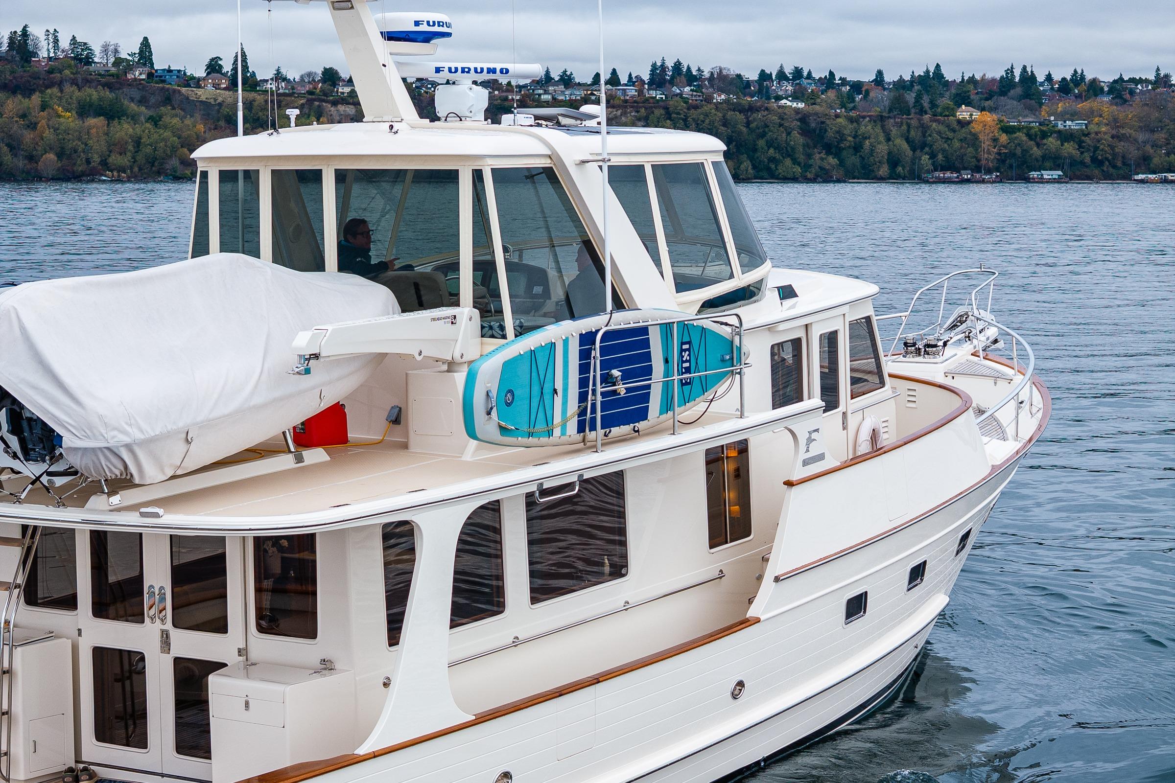2026 Fleming 55 Pilothouse yacht on calm water, featuring a sleek design and modern amenities.