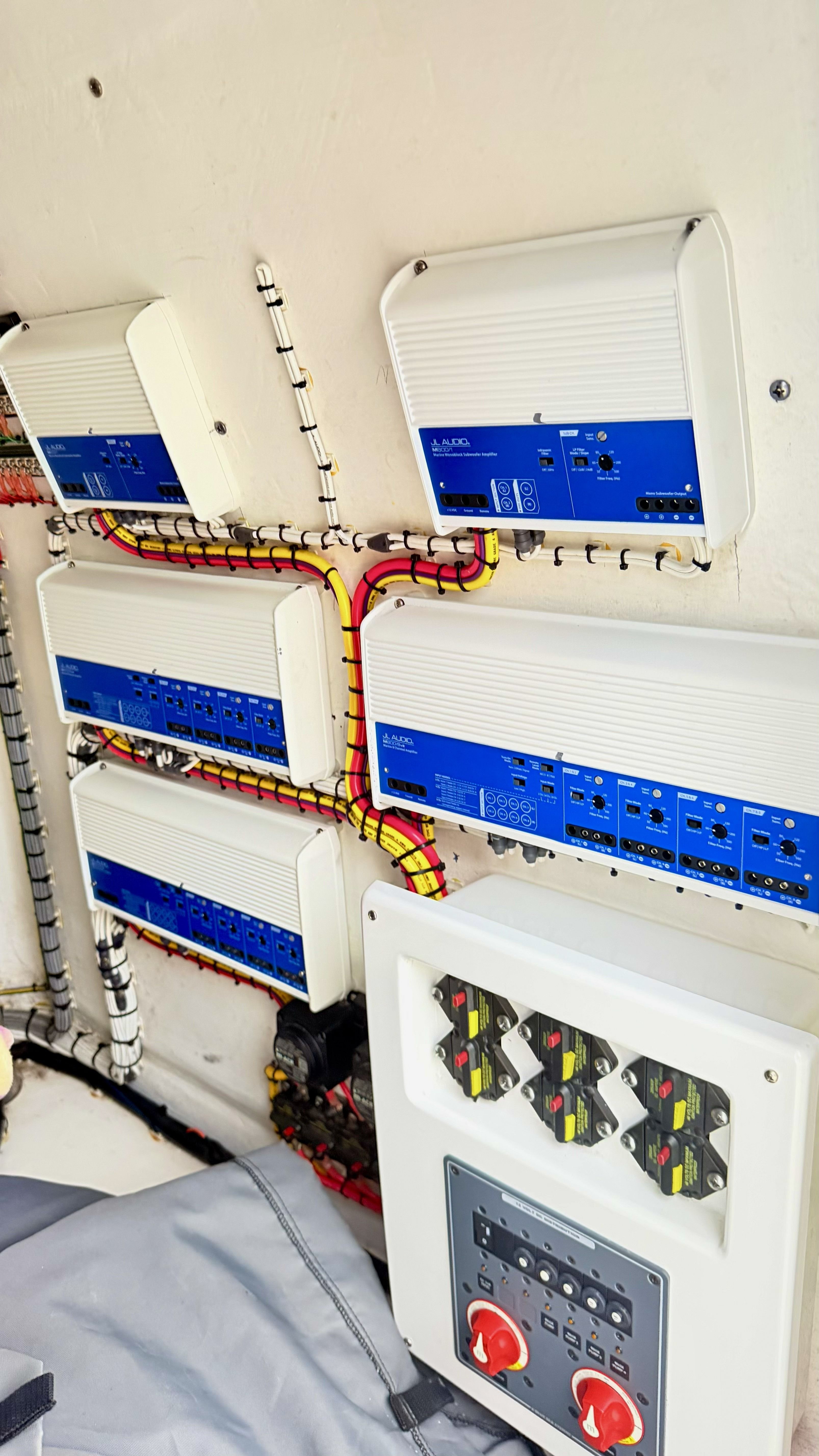 Electronics and control panel inside a boat, featuring multiple blue devices and wiring.