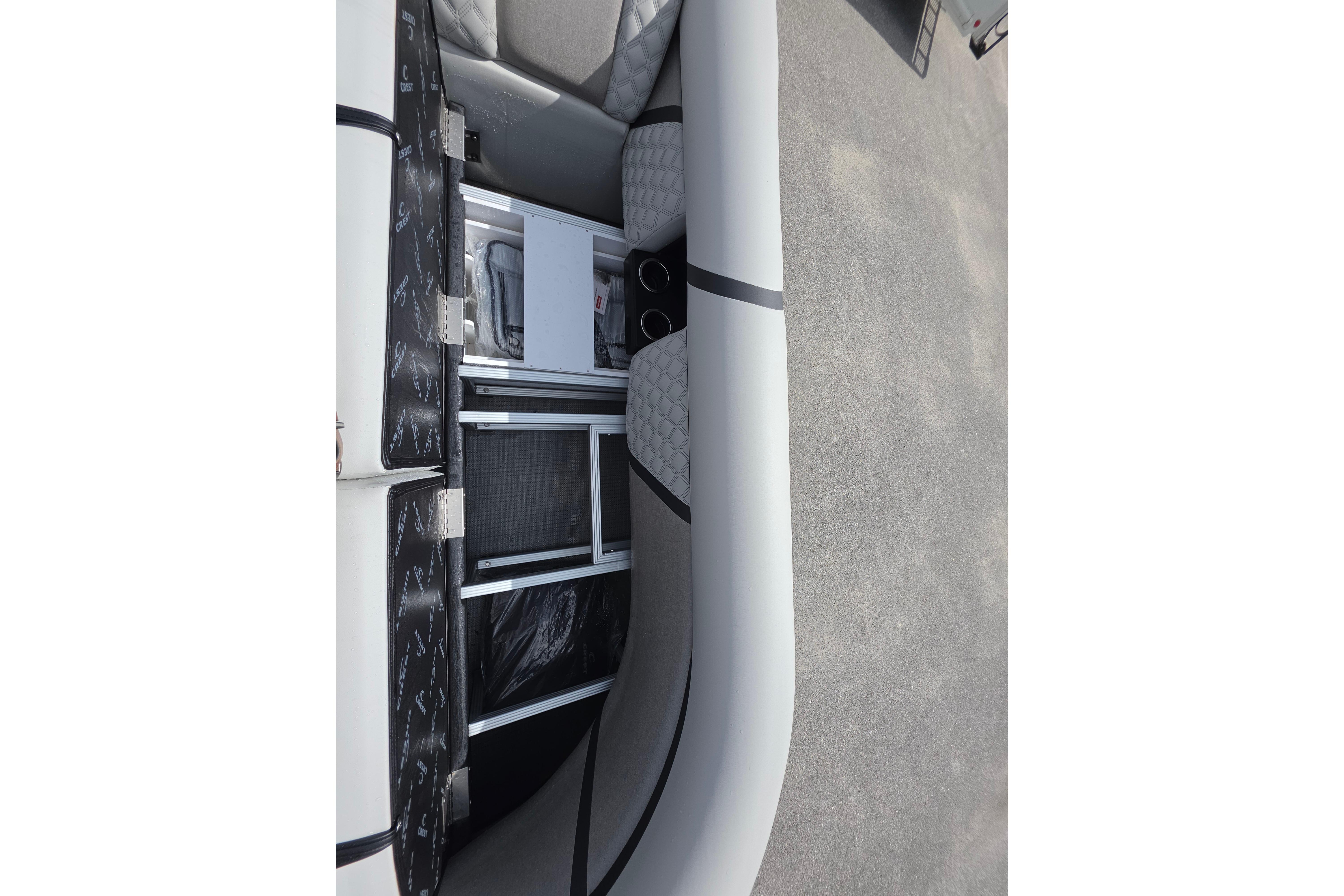 Interior view of 2026 Crest 235 Conquest SLC boat, showcasing seating and storage compartments.