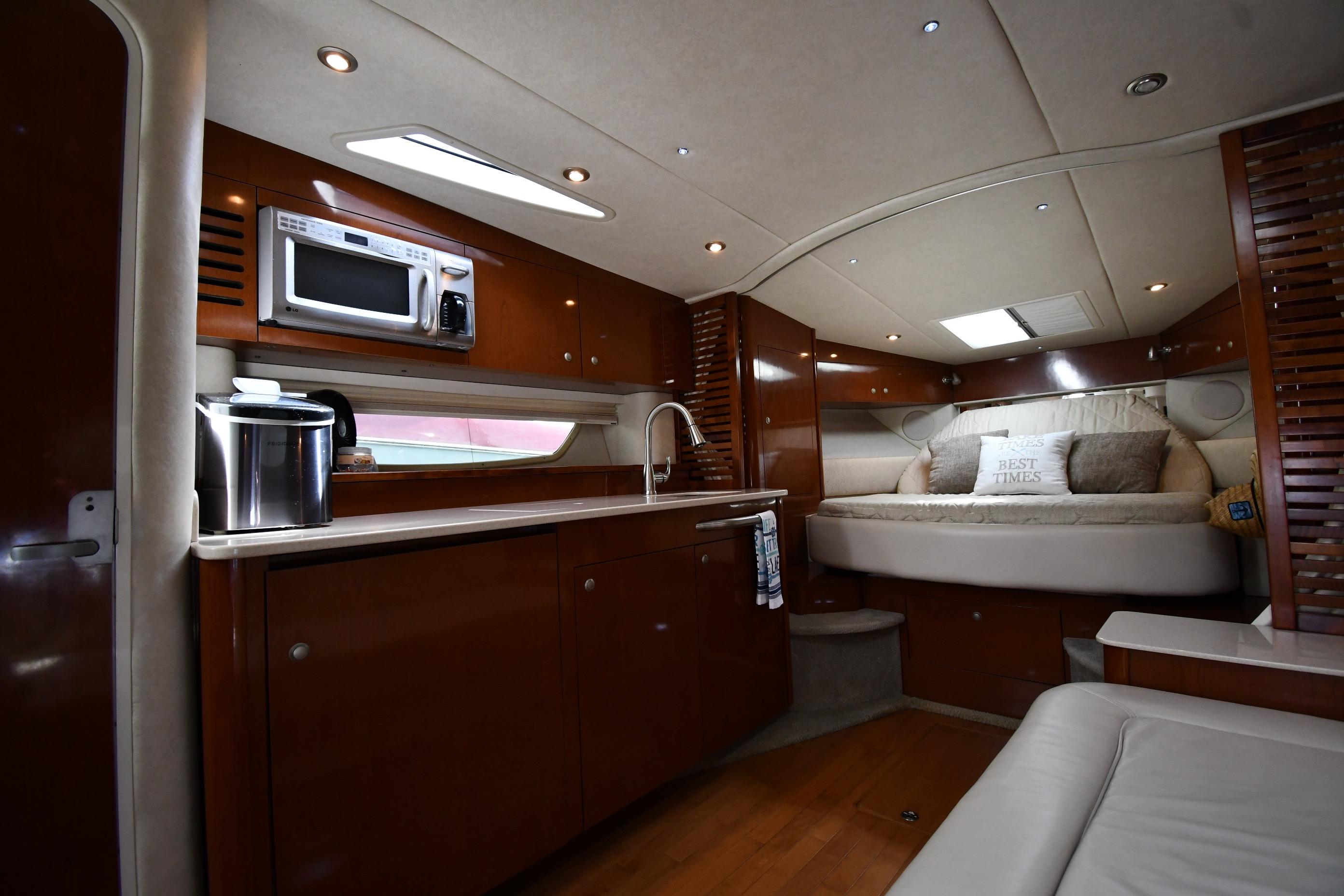Luxurious interior of 2008 Sea Ray Sundancer 350 yacht with kitchenette and cozy sleeping area.