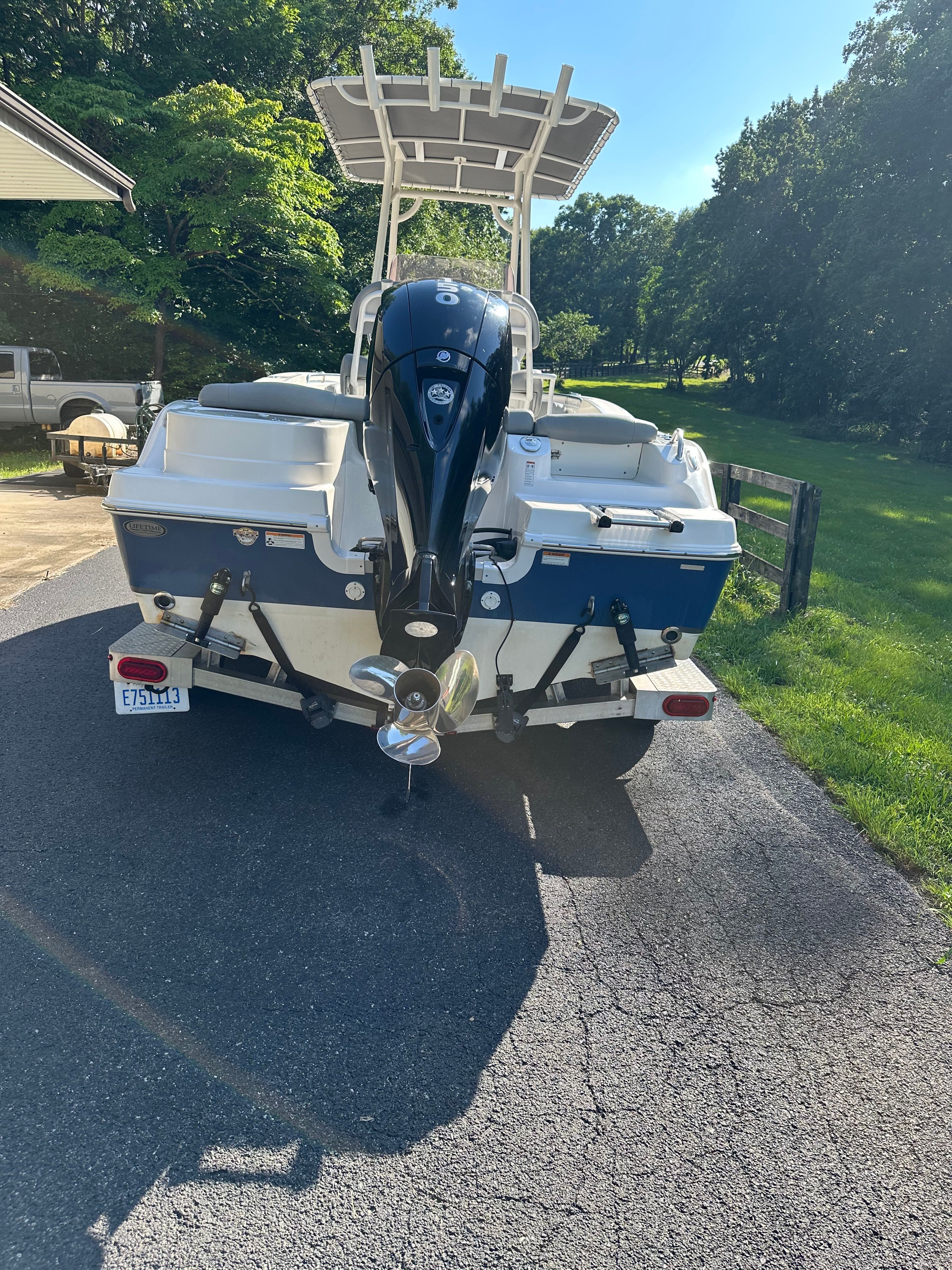 A 2022 NauticStar 2102 Legacy boat on a trailer in a sunny setting.