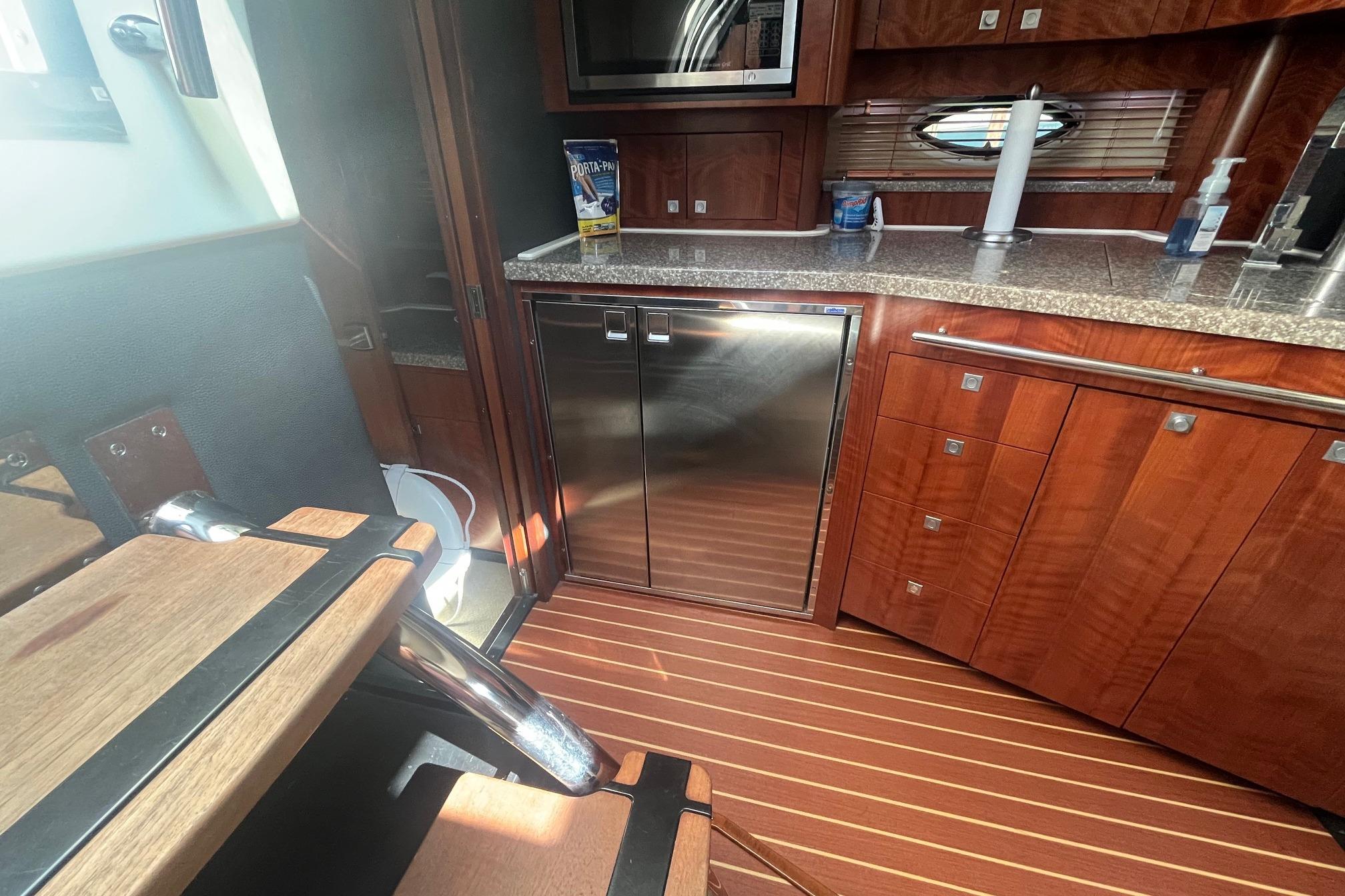 Luxurious interior of 2010 Monterey 400 Sport Yacht with wood cabinetry and stainless steel appliances.