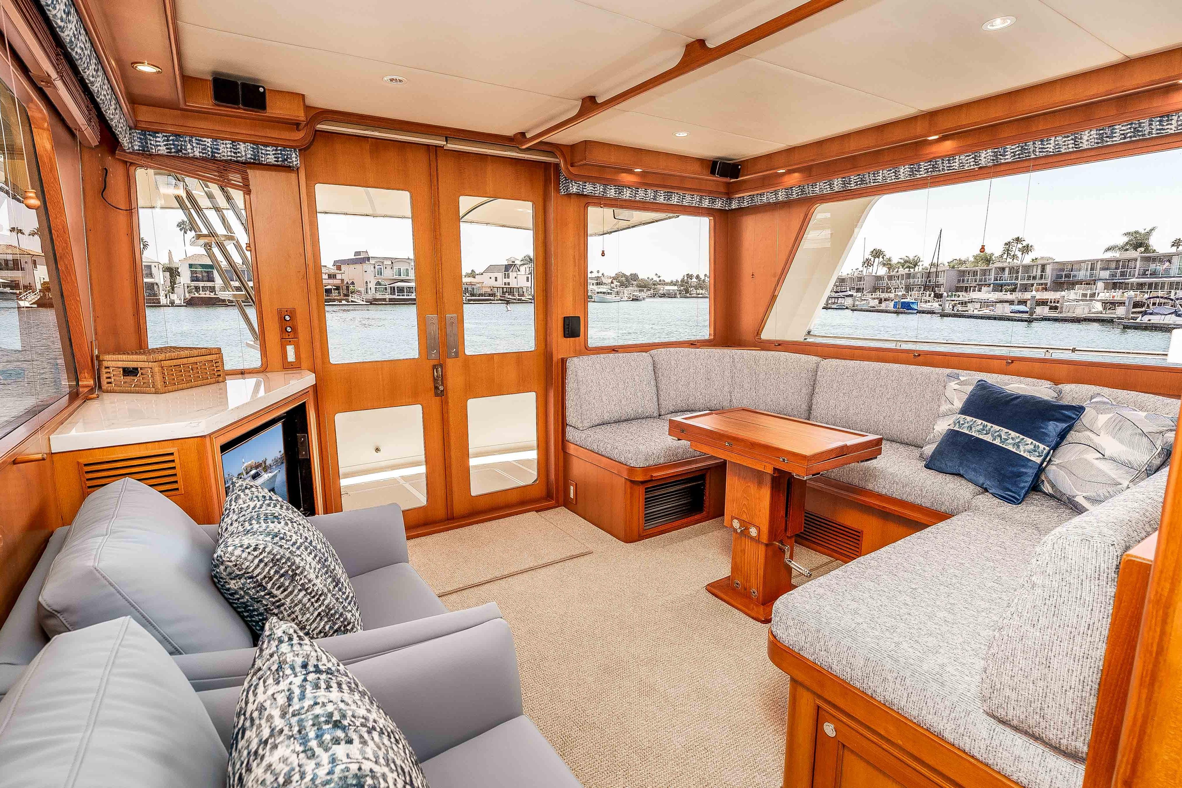 Luxurious interior of 2005 Offshore Yachts 54 Pilothouse with plush seating and waterfront view.