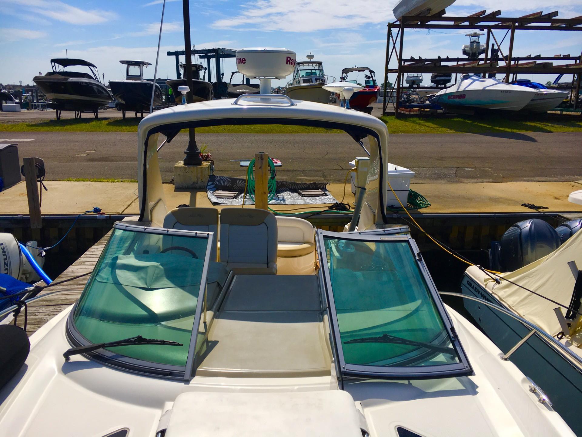 2010 Sea Ray 330 Sundancer docked at marina, showcasing open cockpit and windshield.
