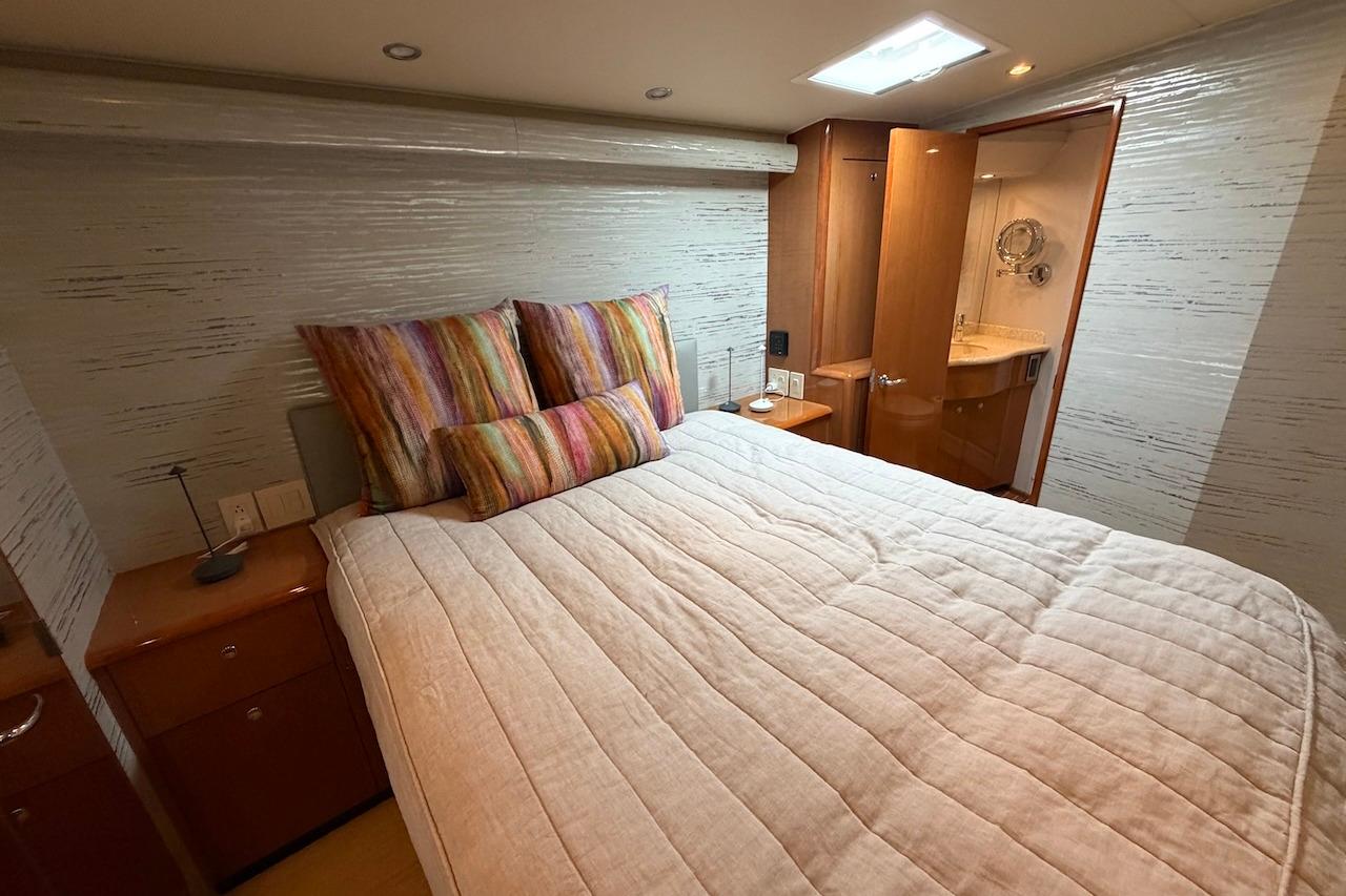 Luxurious bedroom interior of 2004 Viking 56 Convertible yacht with ensuite bathroom.