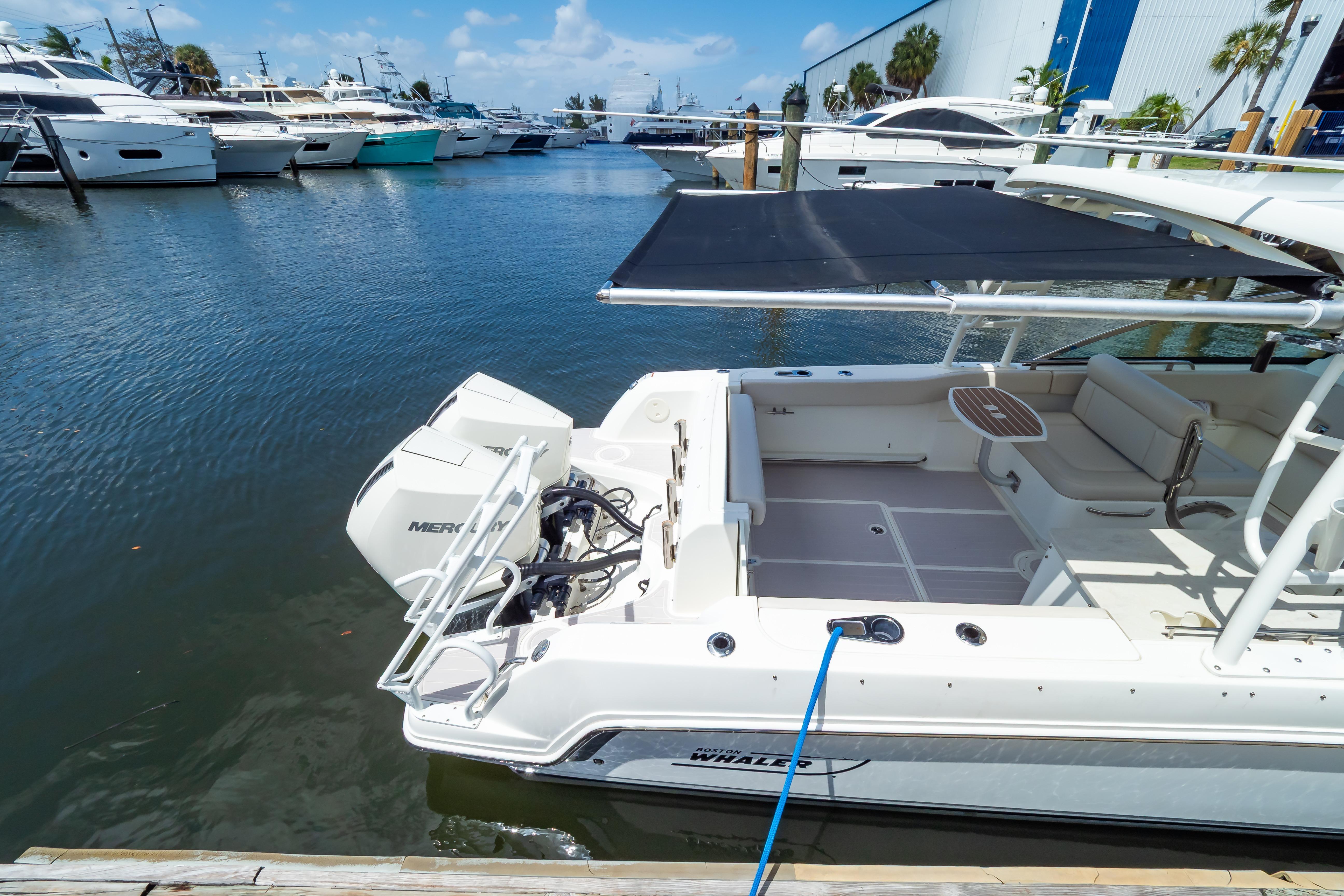 2019 Boston Whaler 270 Vantage docked at marina with other boats.