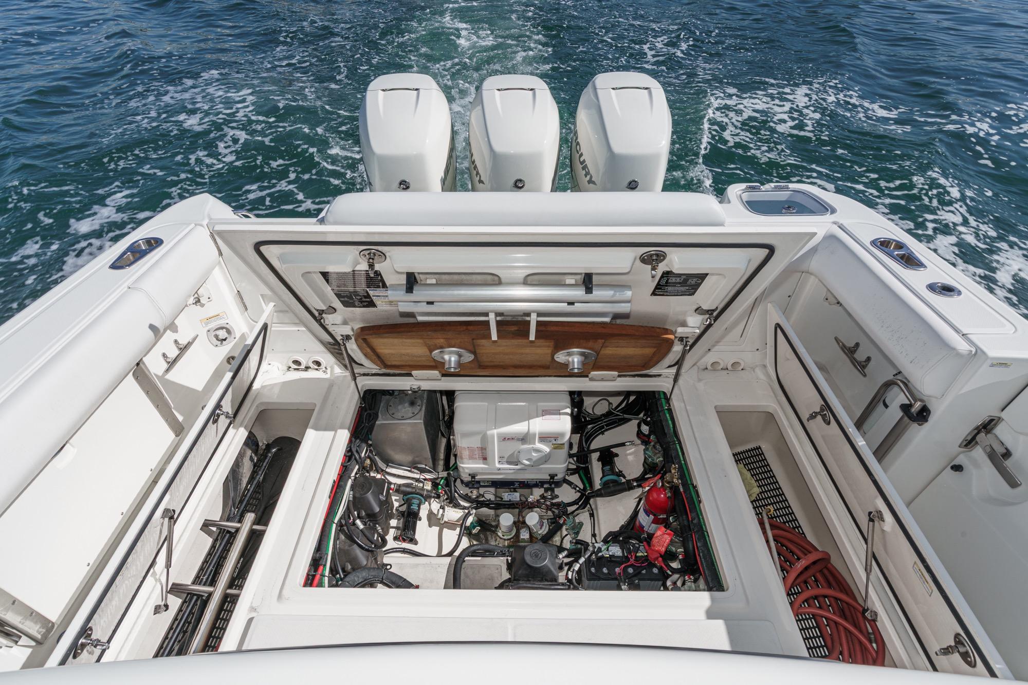 2015 Boston Whaler 370 Outrage engine compartment with triple outboard motors on open water.