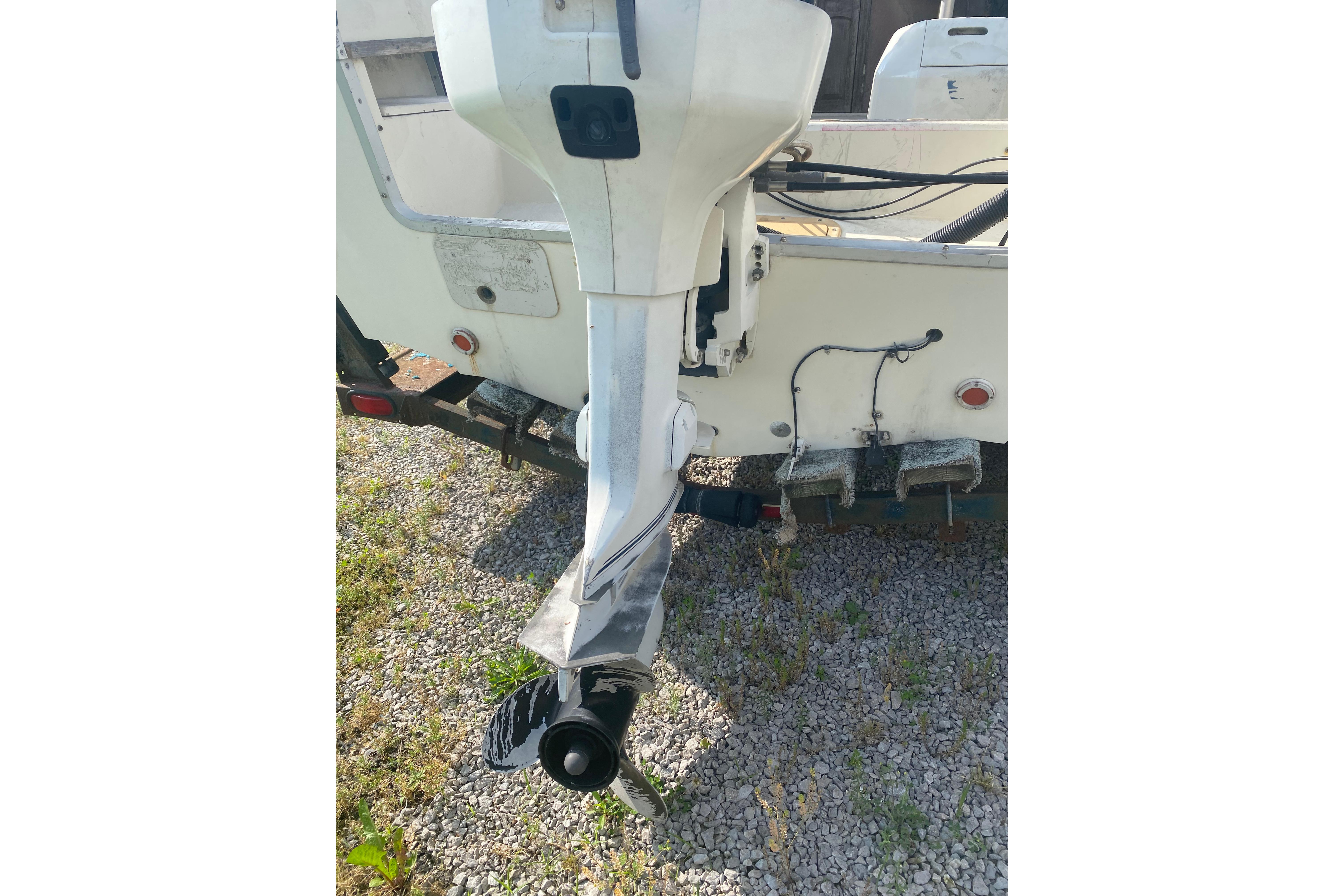 1984 Hydra-Sports 2250 WA boat with outboard motor on gravel surface.