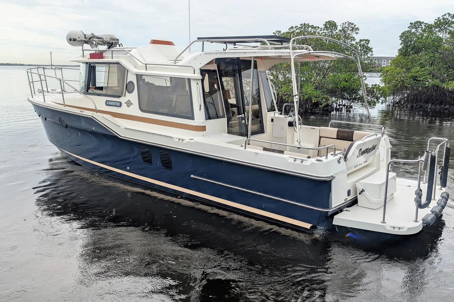 2015 Ranger Tugs R-29 S boat docked on calm water, featuring a sleek design.