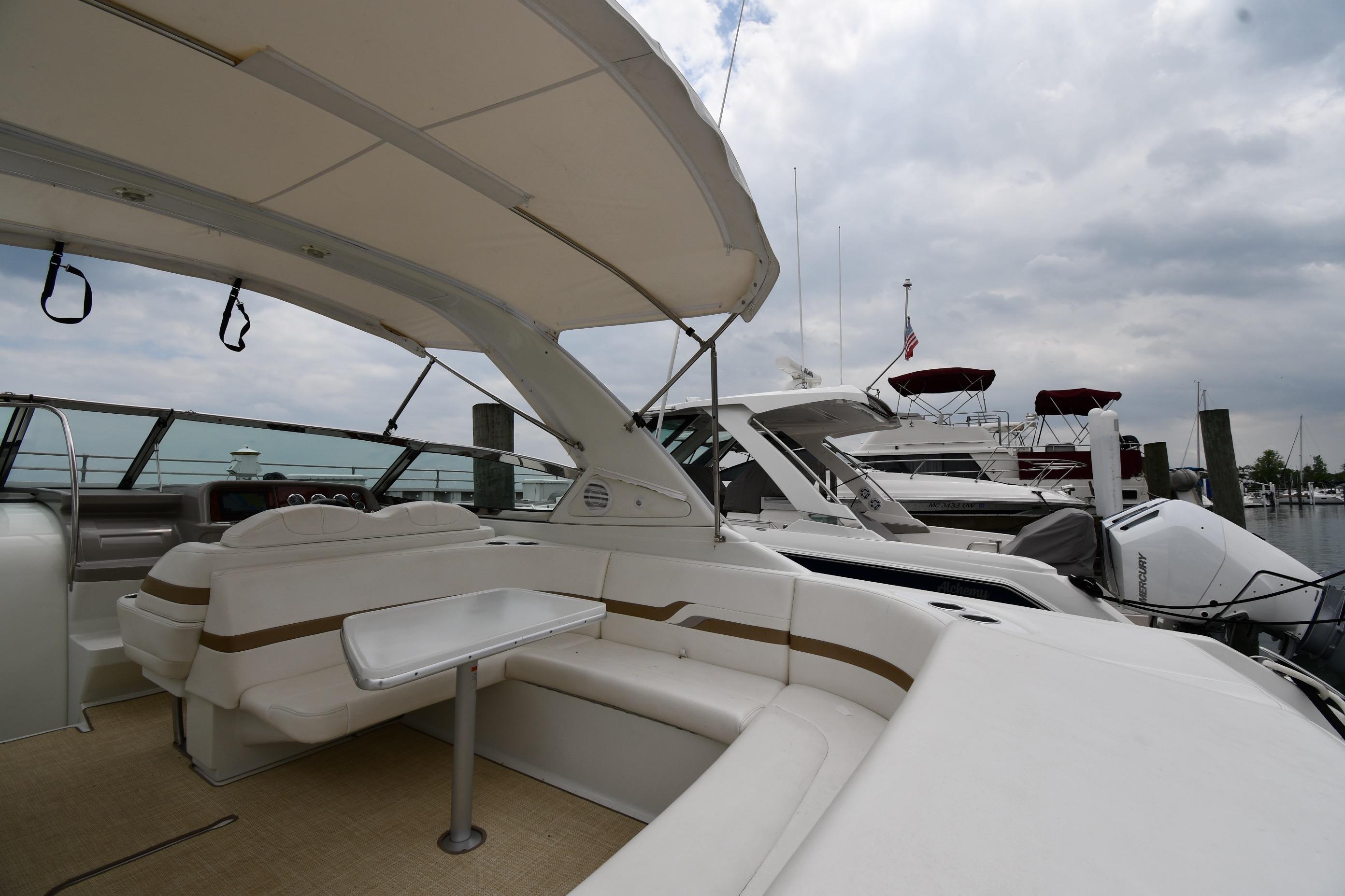 2004 Formula 330 Sun Sport yacht interior with seating and table at marina.