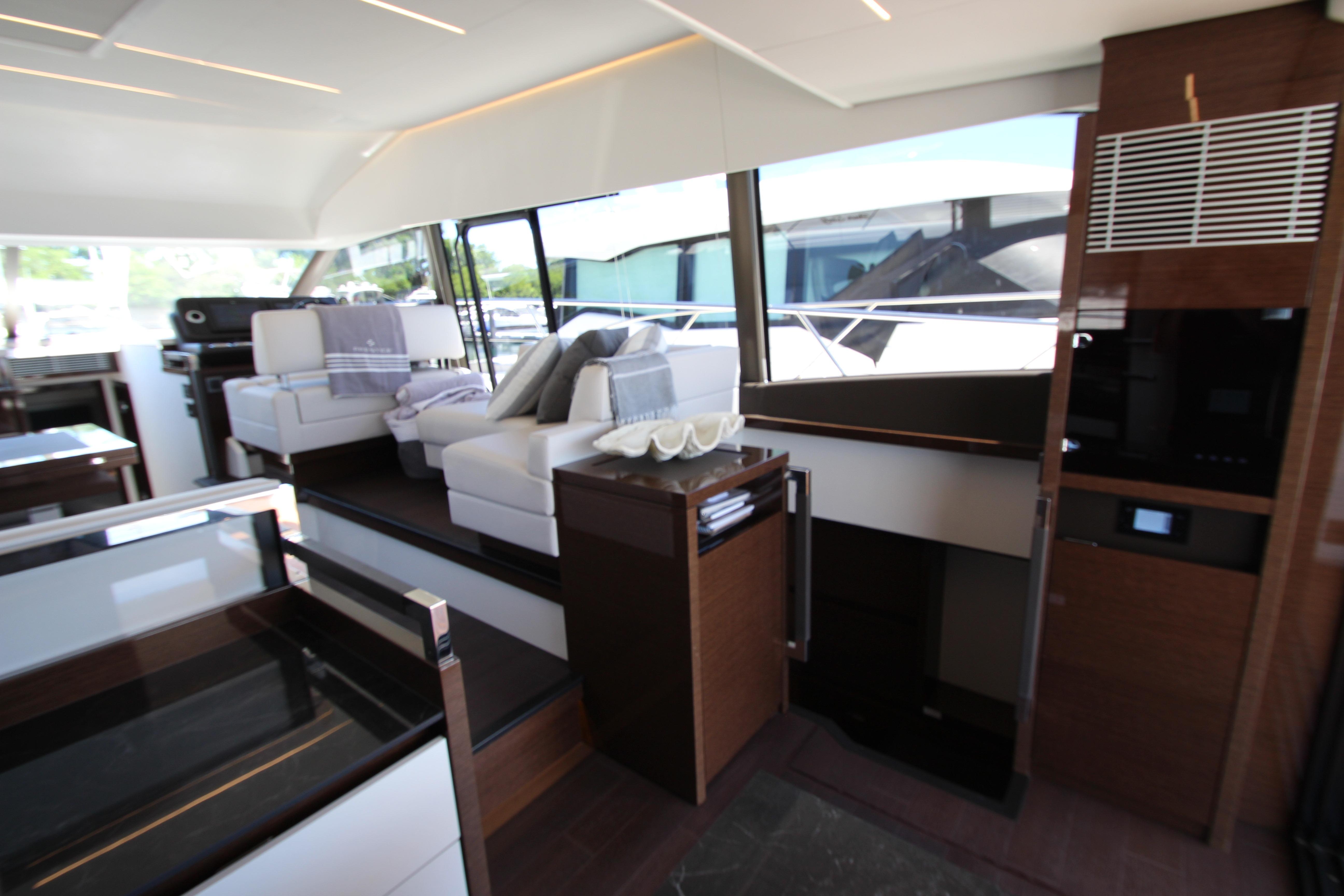 Luxurious interior of a 2022 Prestige 520 yacht with modern furnishings and large windows.