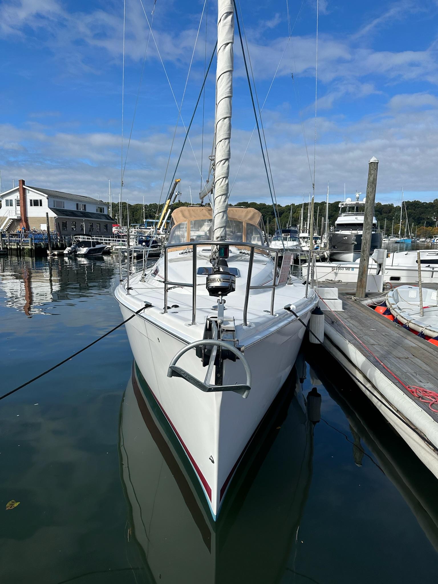 2005 Hunter 38 sailboat docked in a marina under a clear blue sky.