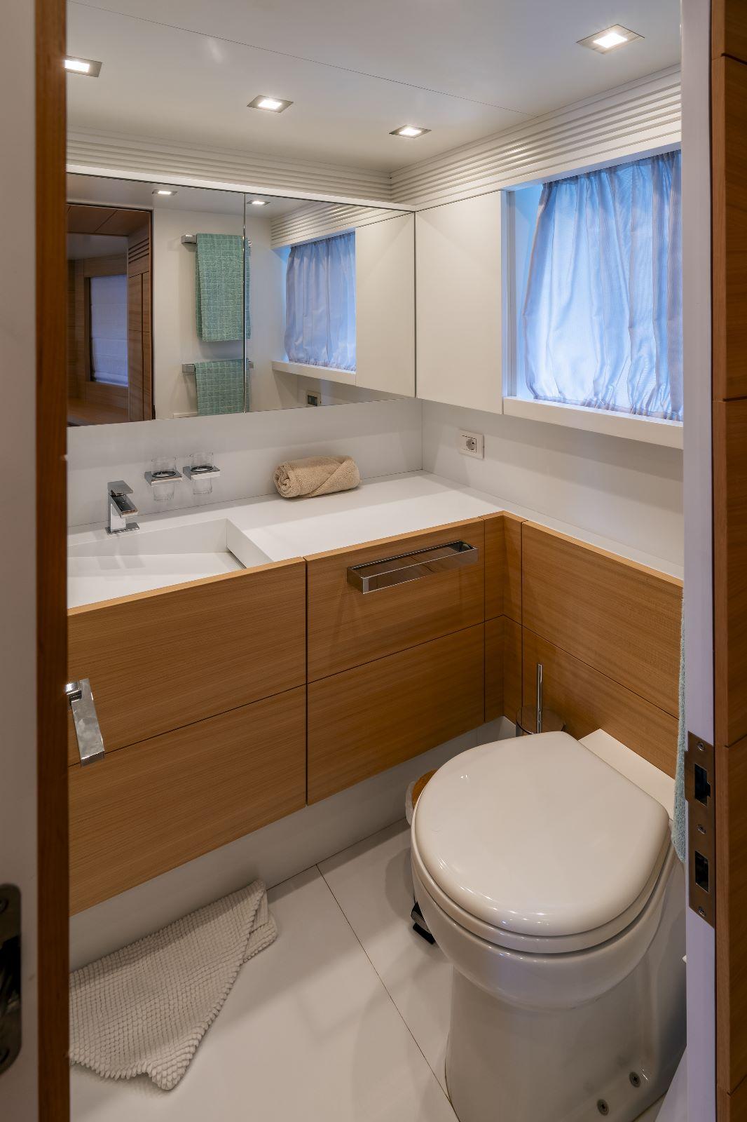 Luxurious bathroom in a 2011 Maiora 27 yacht, featuring modern fixtures and elegant wood accents.