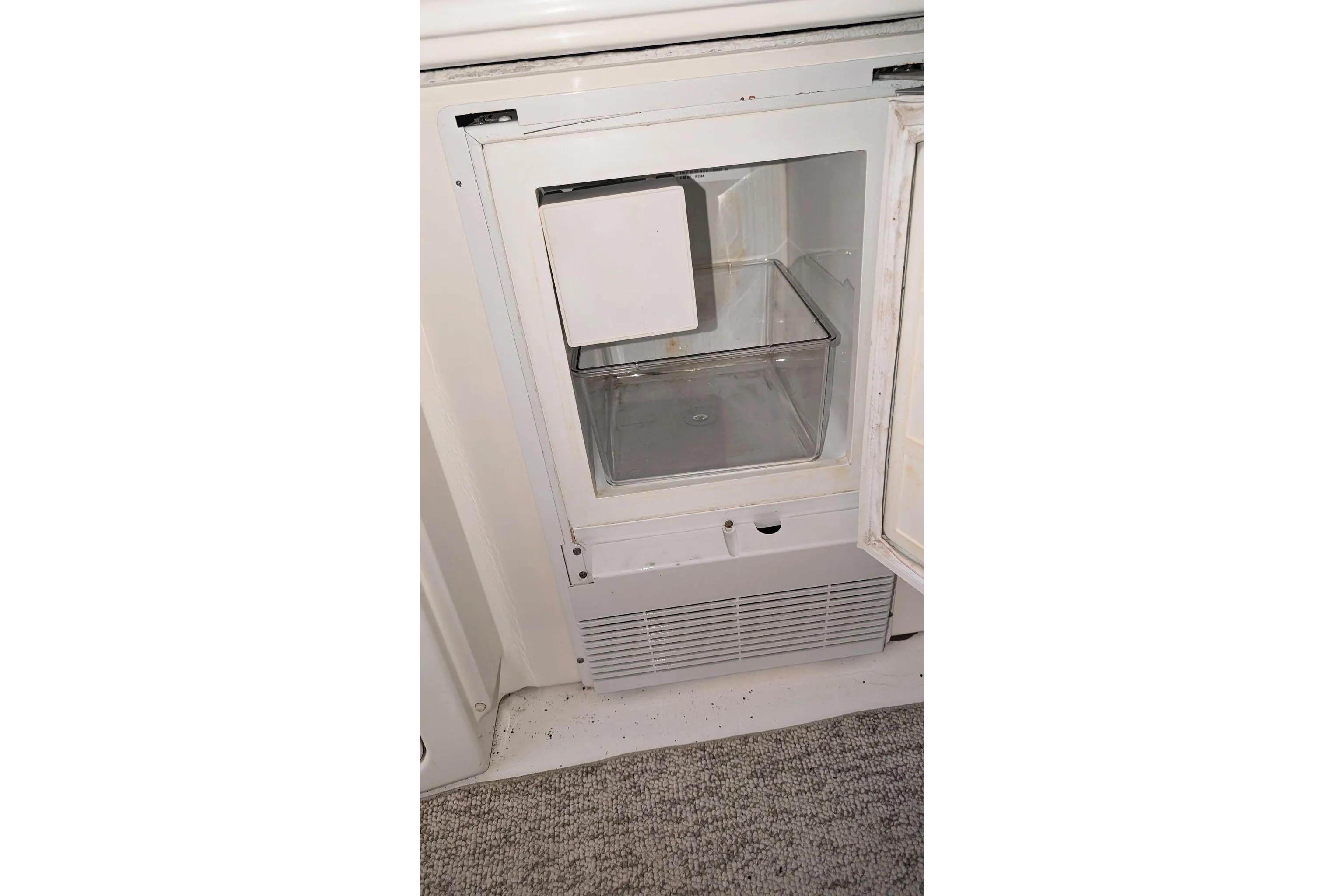 Open refrigerator on a 2000 Sea Ray 380 Sundancer boat, showing interior storage space.