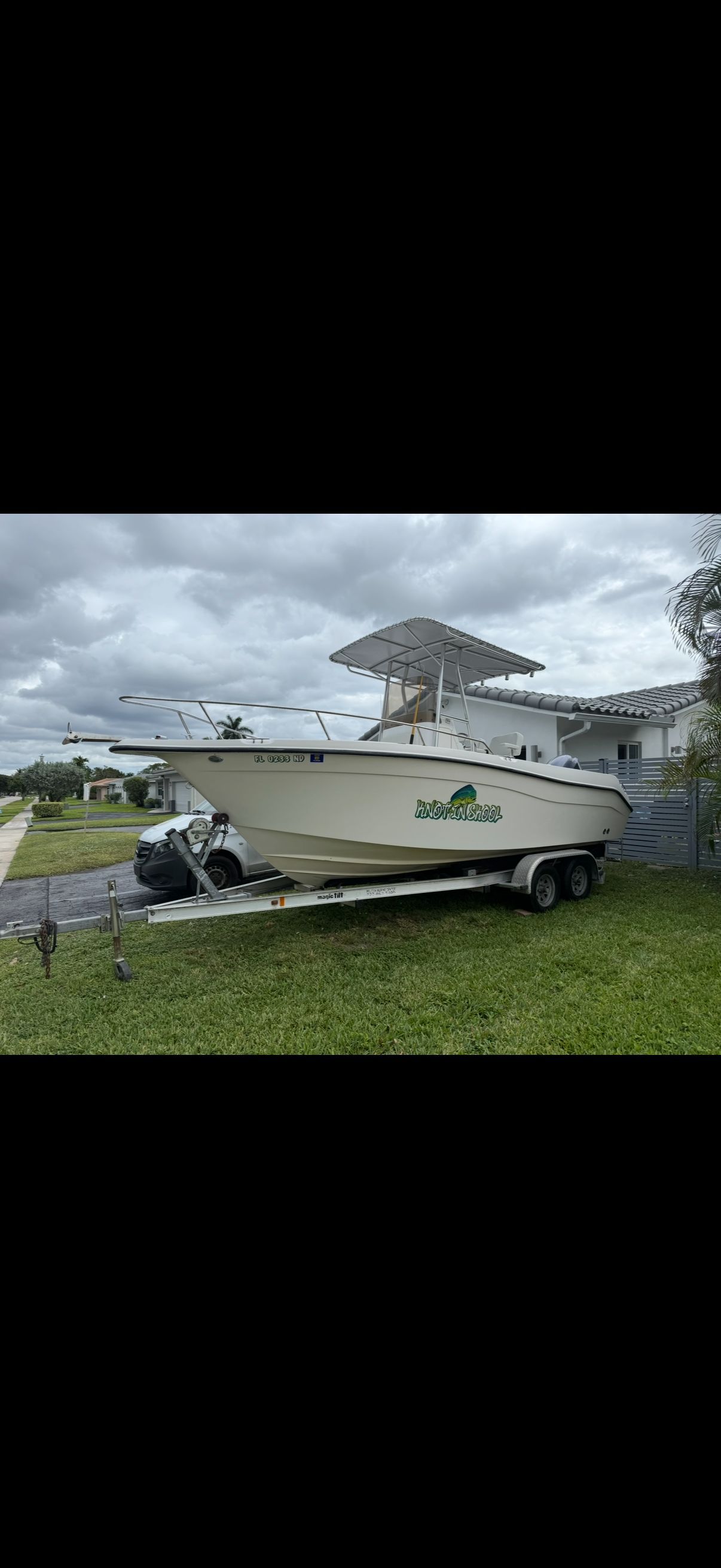 2006 Seaswirl Striper Center Console on trailer, cloudy sky.