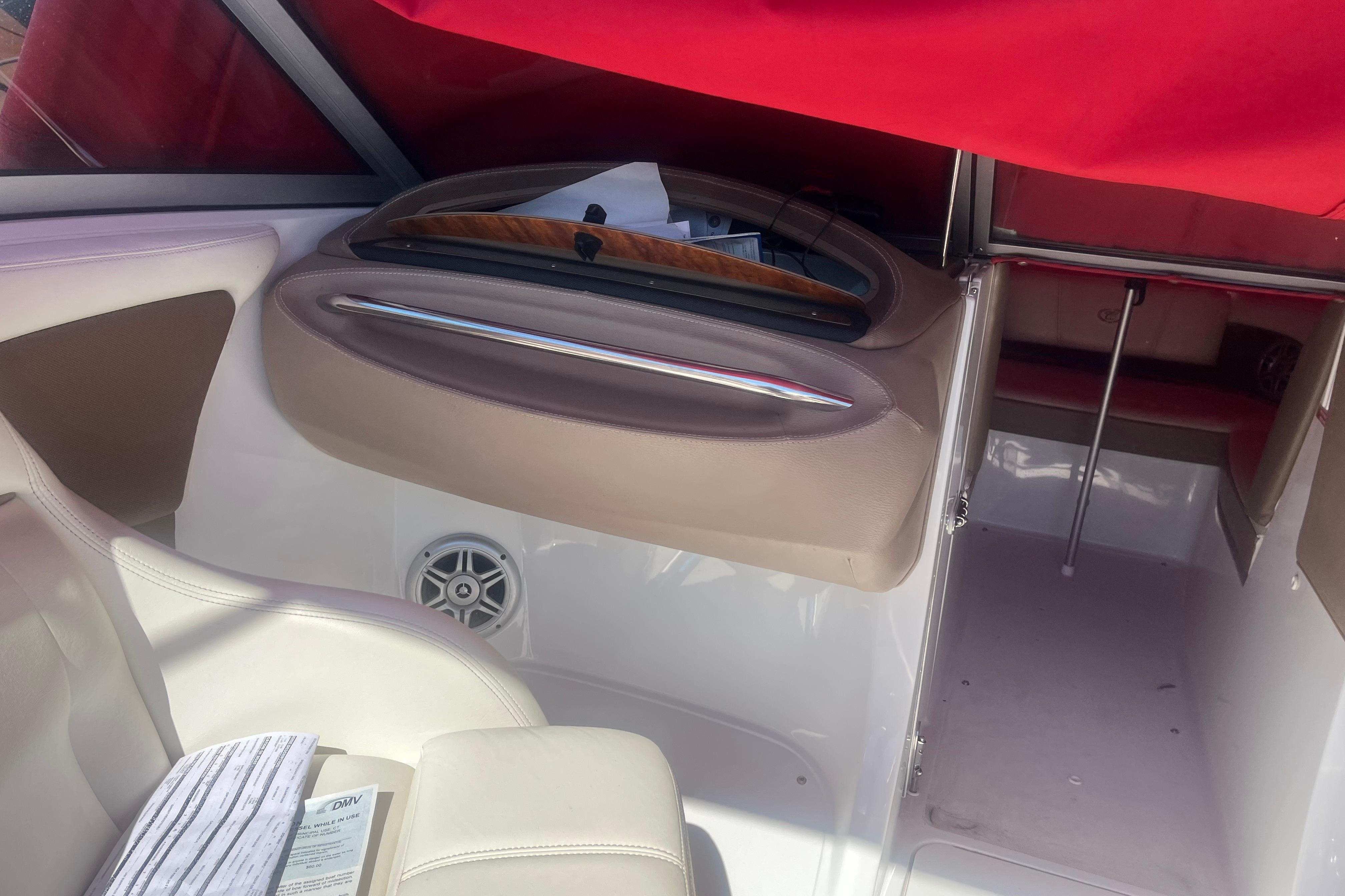 Interior of a 2011 Cobalt 210 boat with red canopy and beige seating.