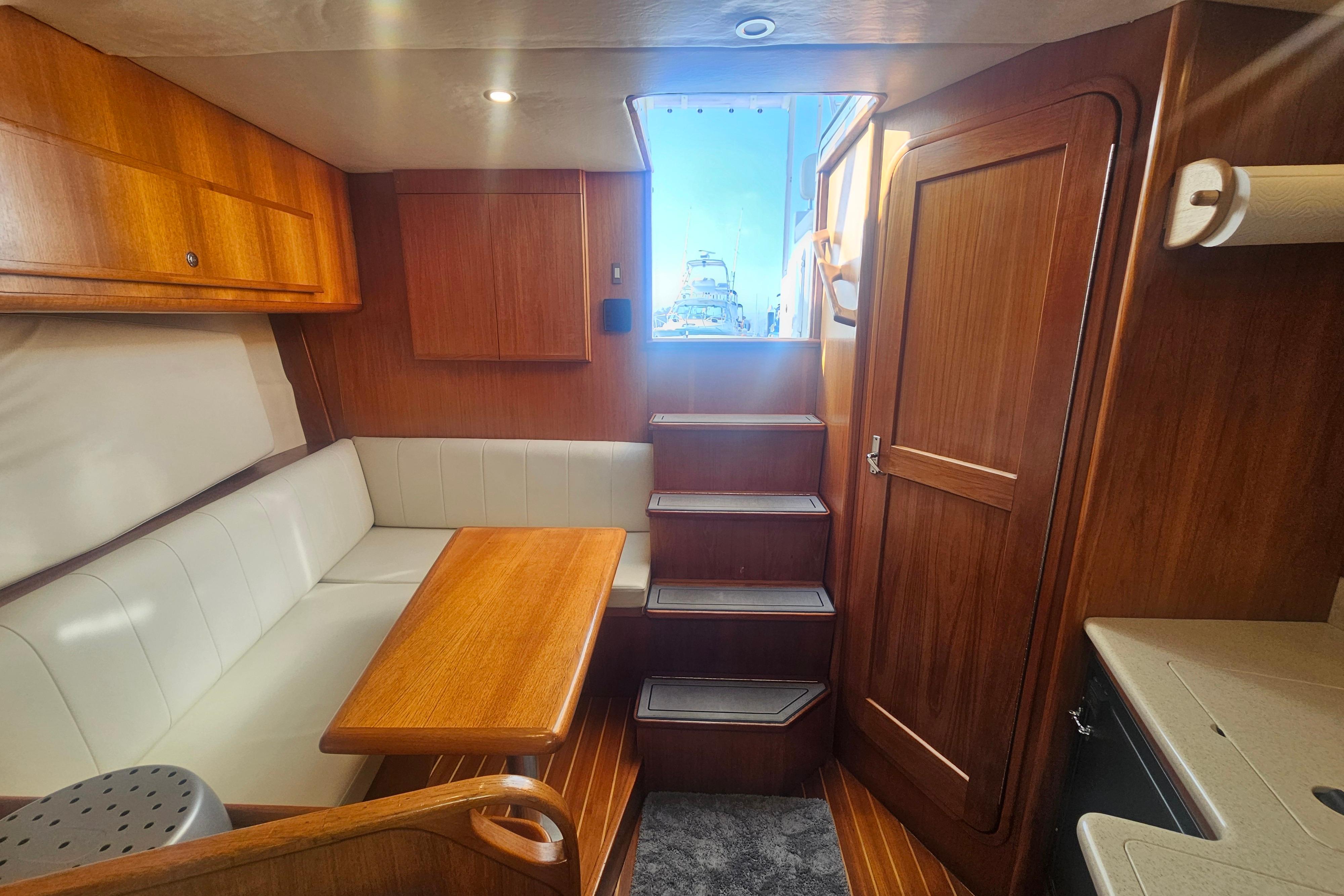 Interior of 2003 Topaz 32 Express boat with wooden finishes and seating area.