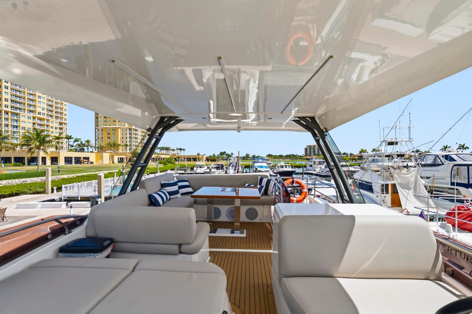 Luxurious 2022 Prestige 520 yacht interior at marina, featuring plush seating and modern design.