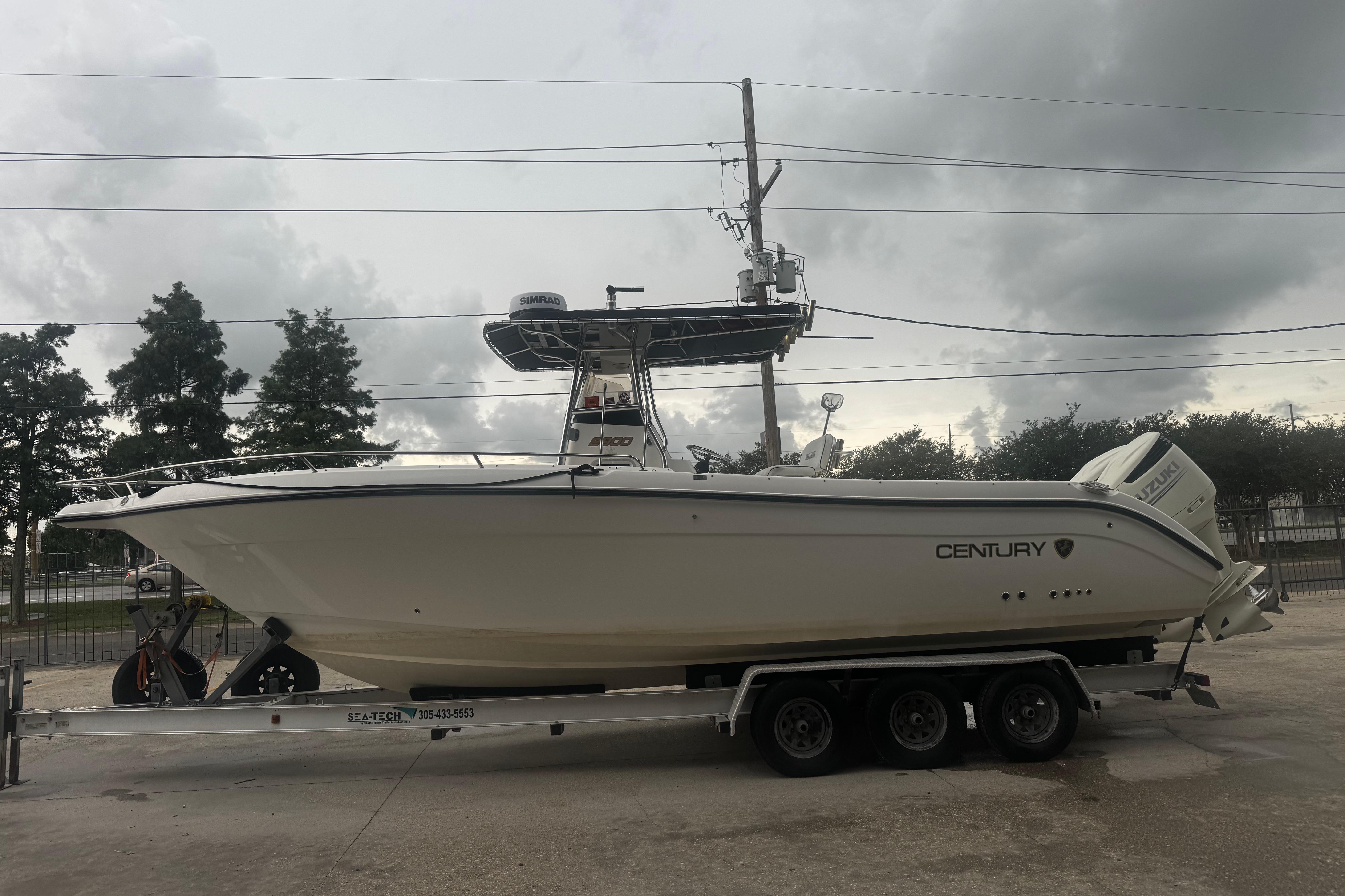 2004 Century 2900 Center Console boat on trailer under cloudy sky.