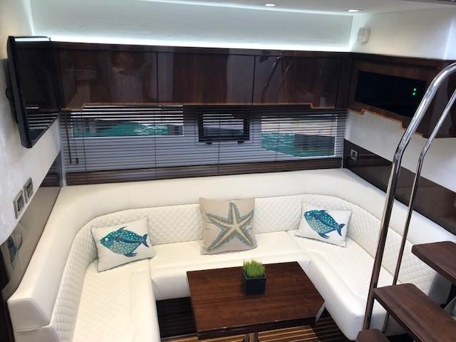 Luxurious interior of 2018 Galeon 485 yacht with white seating and decorative pillows.