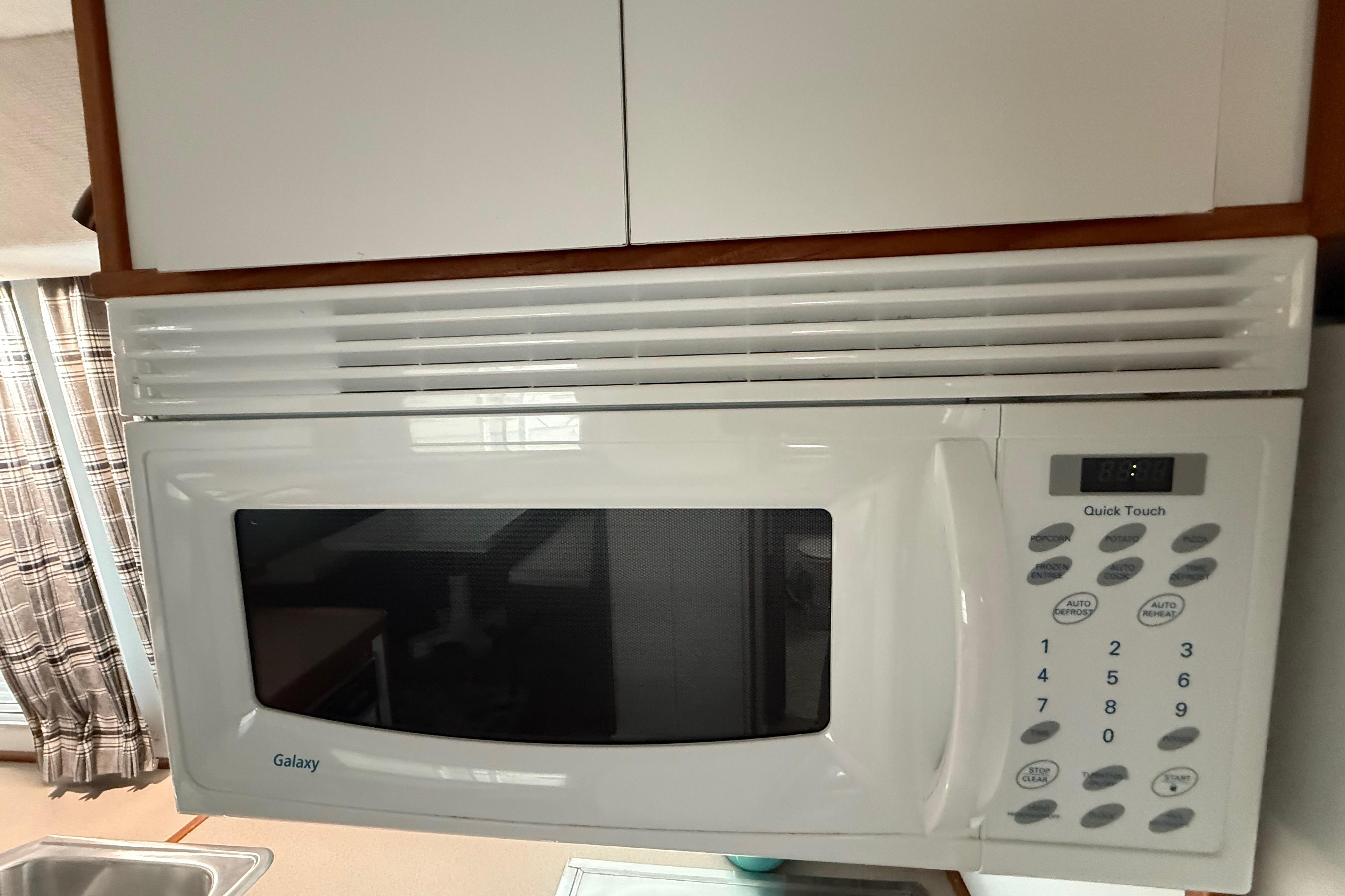 White Galaxy microwave with digital controls in a 1995 Harbor Master 52 Wide Body kitchen.