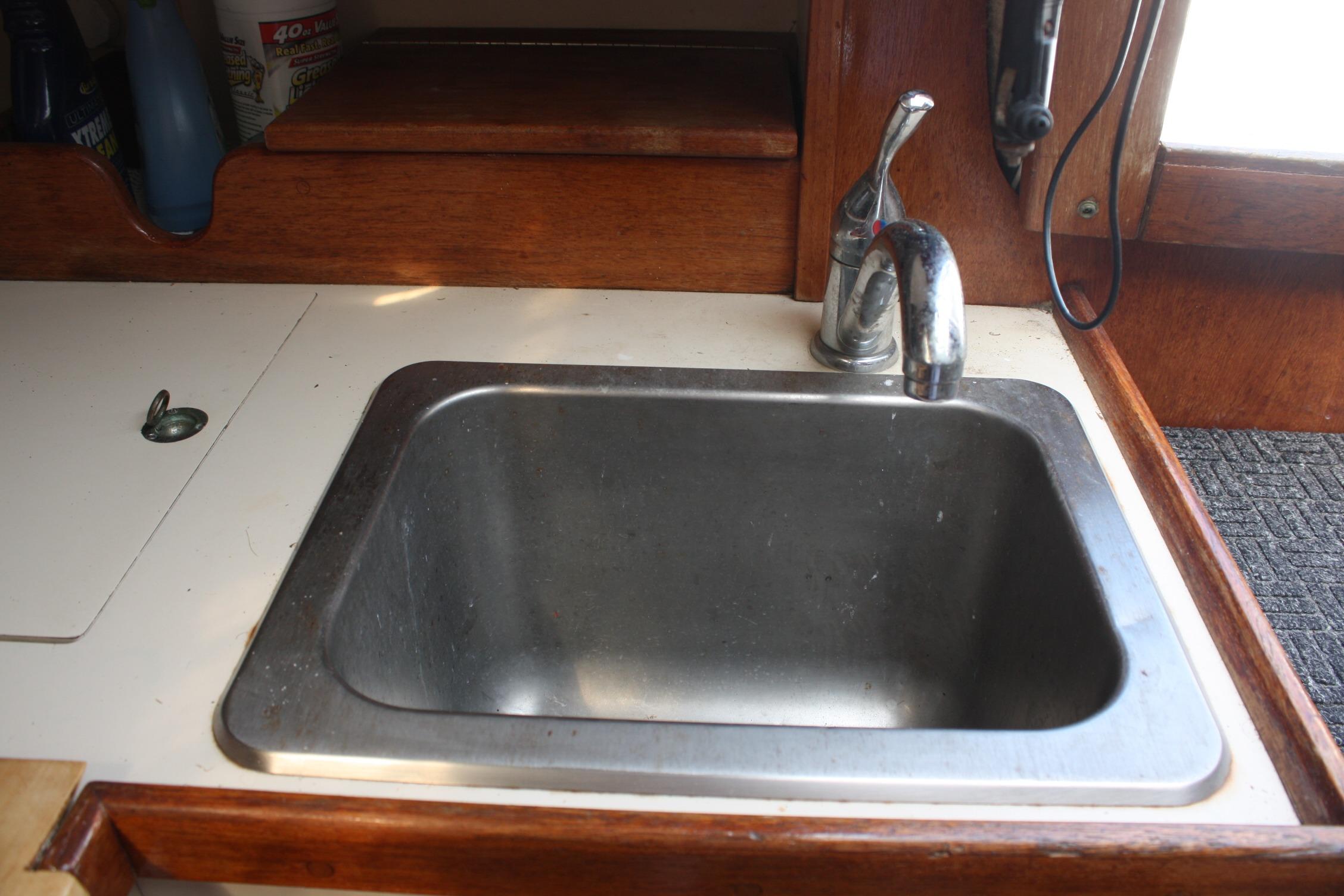 Stainless steel sink in 1981 S2 9.2A boat galley with wooden trim.