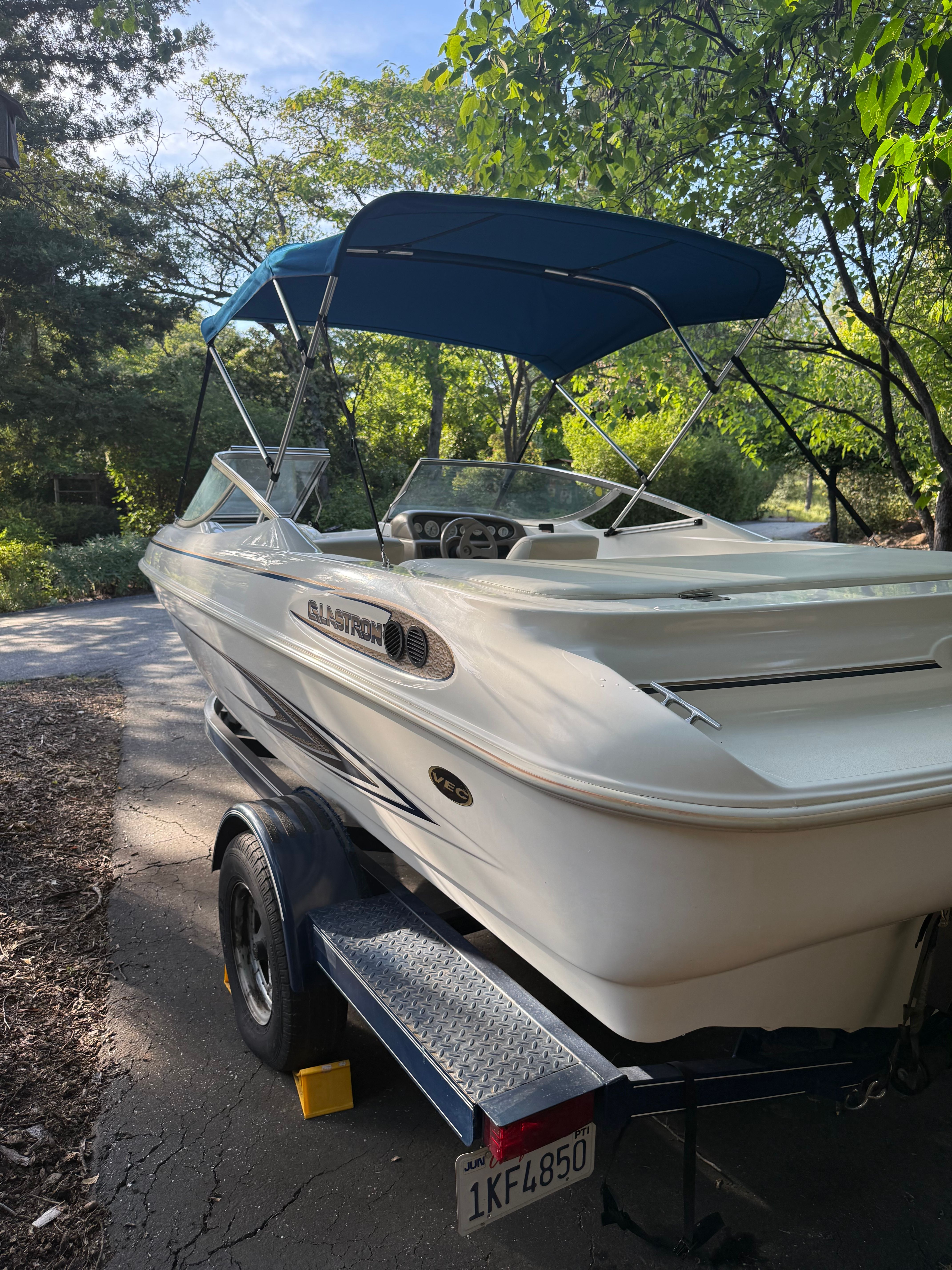 2003 Glastron SX 195 boat with blue canopy on trailer.