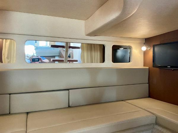 Interior of 2014 Sea Ray 330 Sundancer yacht with beige seating and wall-mounted TV.