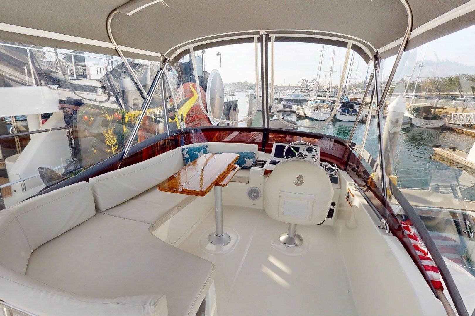 Flybridge of 2021 Beneteau Swift Trawler 35 with seating and helm, docked at marina.