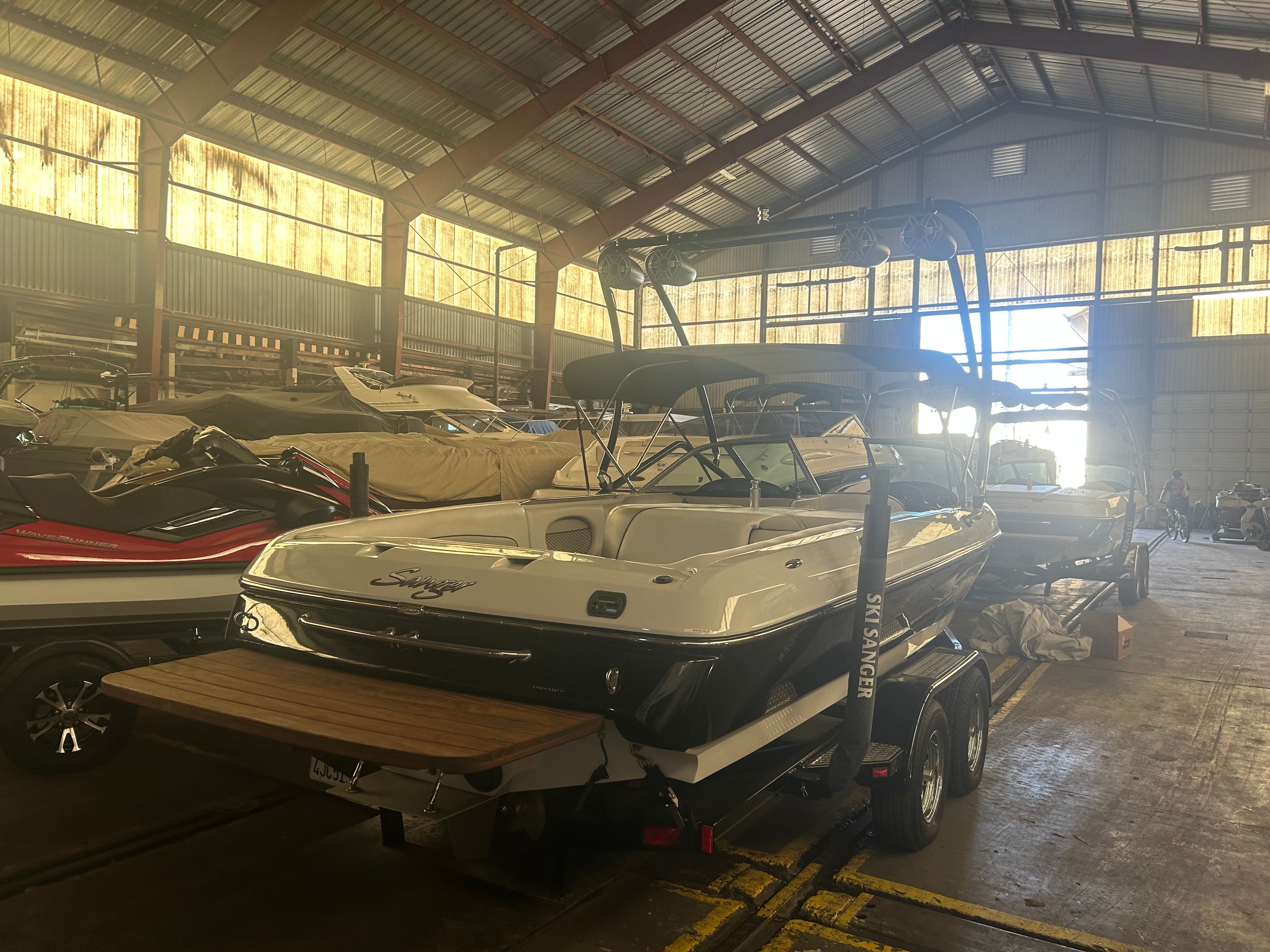 A 2007 Sanger boat is on a trailer inside a storage warehouse.