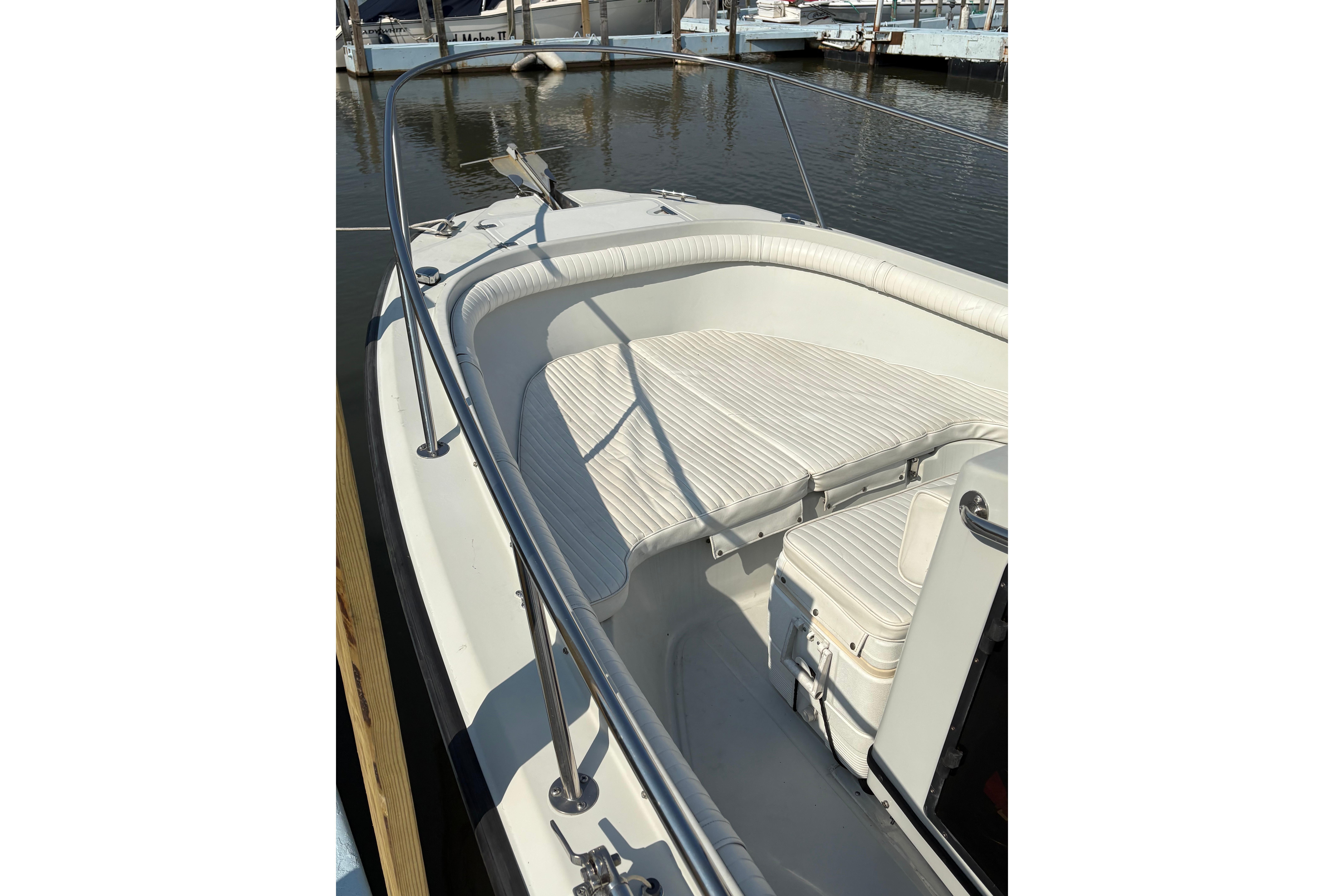 1993 Boston Whaler 21 Outrage boat with white seating, docked in a marina.